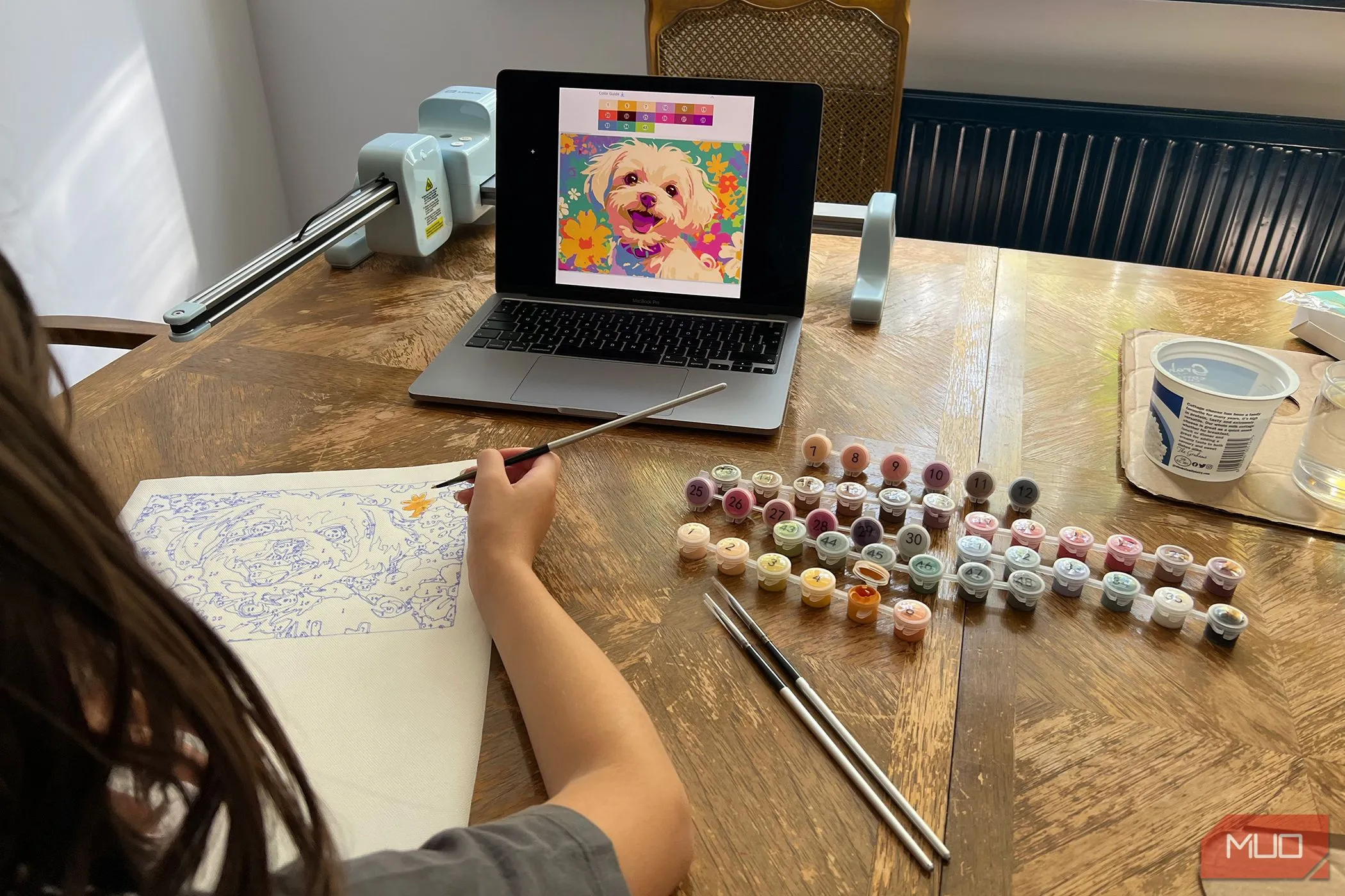 Bé gái đang say sưa tô màu bức tranh chú chó được tạo bởi máy LOKLiK iPaint.