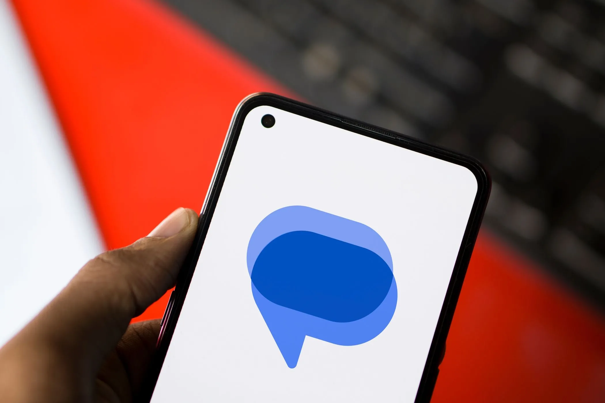 Biểu tượng Google Messages trên màn hình điện thoại Android với bàn phím phía sau, minh họa ứng dụng SafetyCore quét ảnh