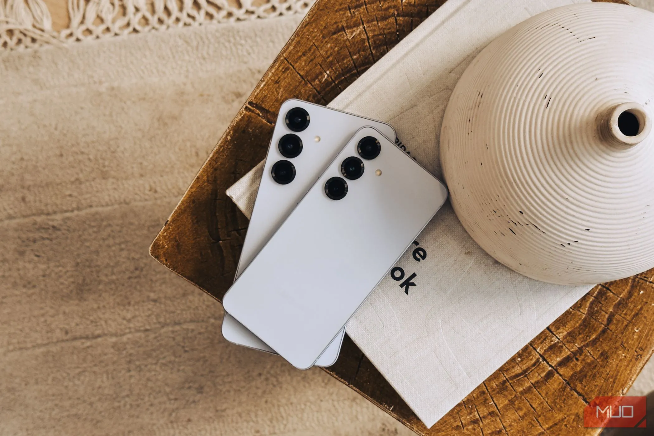 Bộ đôi Samsung Galaxy S25 và S25+ đặt chồng lên nhau trên sách