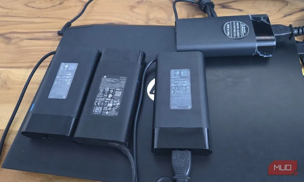 Bốn củ sạc HP 150W xếp chồng lên nhau trên laptop HP, minh họa chi phí và rủi ro khi chỉ có một cổng sạc laptop laptop duy nhất.