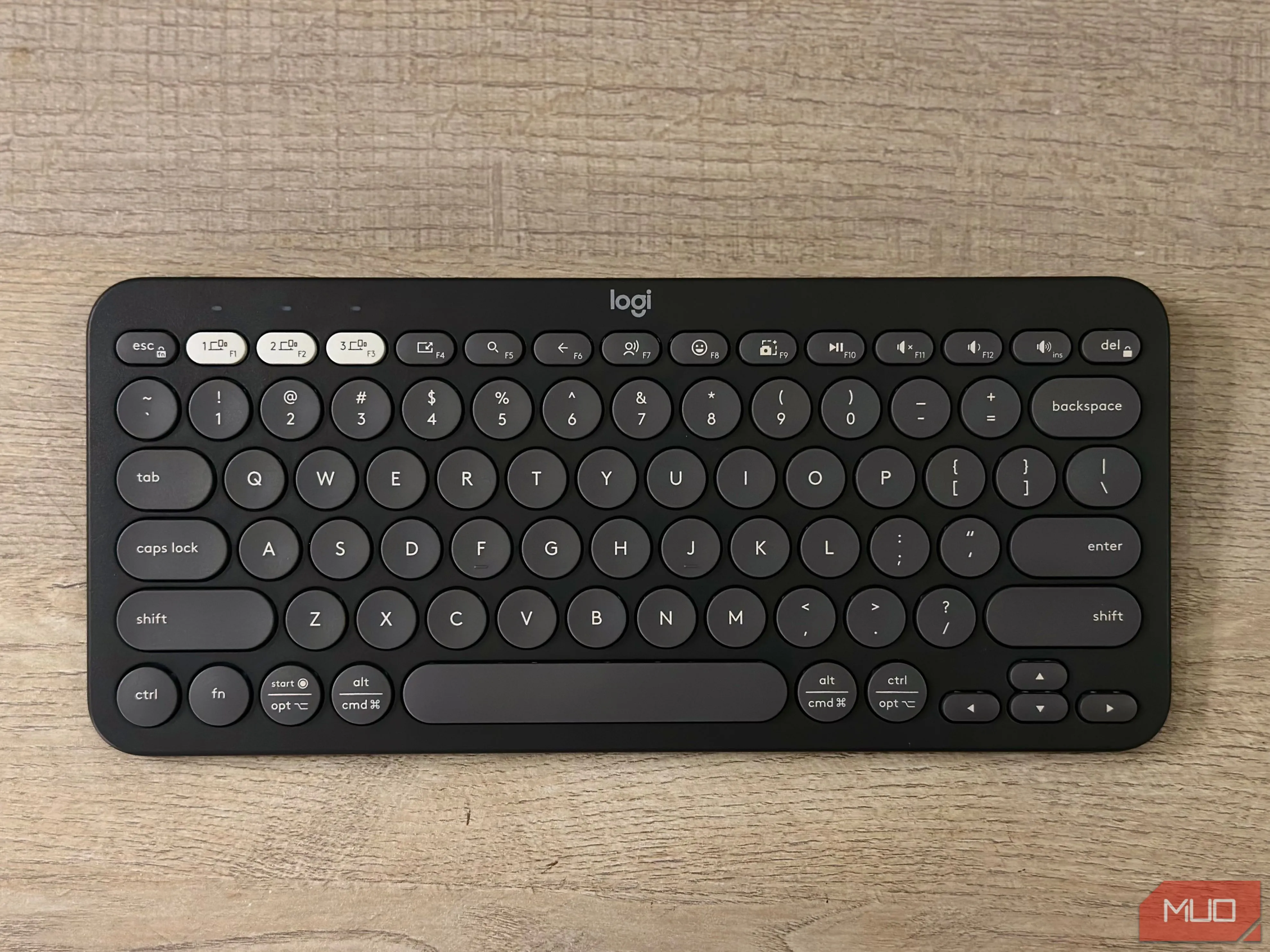 Cận cảnh bàn phím Logitech Pebble Keys 2 K380s màu trắng trên bàn, được sử dụng để làm việc với iPad