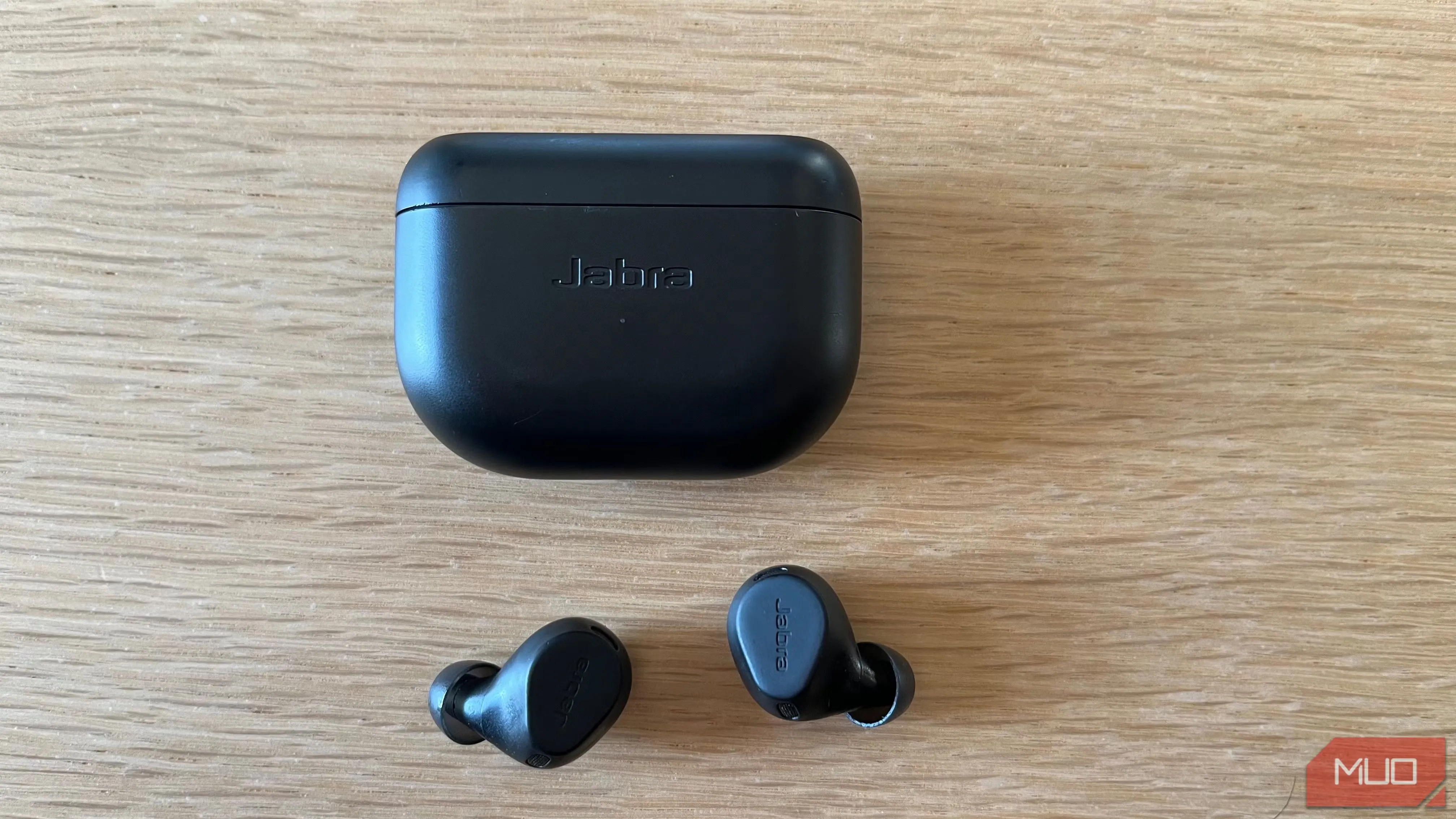 Cặp tai nghe không dây Jabra Elite 8 Active chống ồn màu đen đặt trên bàn gỗ