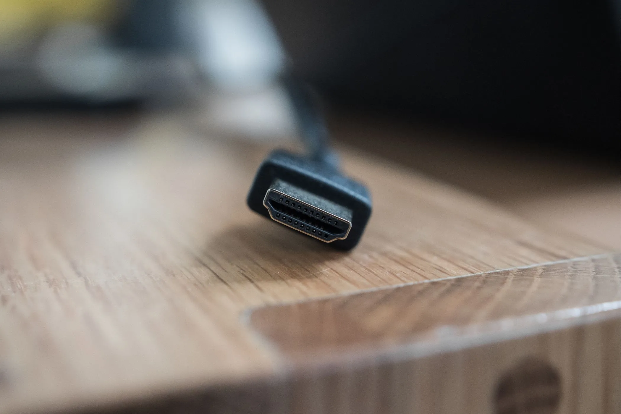 Đầu nối cáp HDMI tiêu chuẩn đặt trên bàn gỗ, minh họa giải pháp cho một cổng HDMI