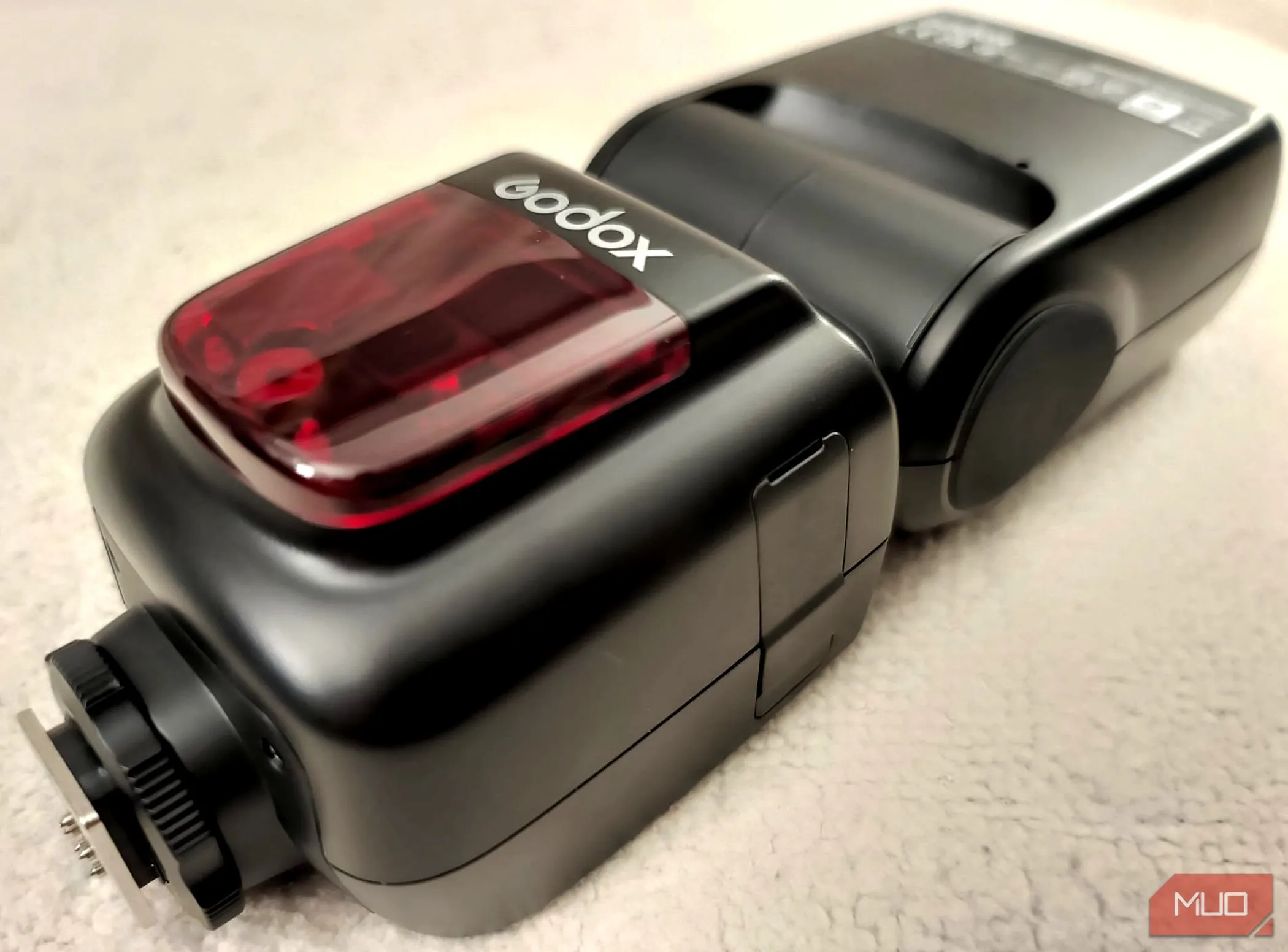 Đèn flash Godox V860II-C đặt trên nền vải, cho thấy thiết kế chắc chắn và chất lượng hoàn thiện bền bỉ của dòng đèn Godox VING.