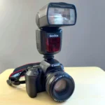 Đèn flash Godox V860II gắn trên thân máy ảnh chuyên nghiệp, minh họa lợi ích của đèn flash rời trong nhiếp ảnh.