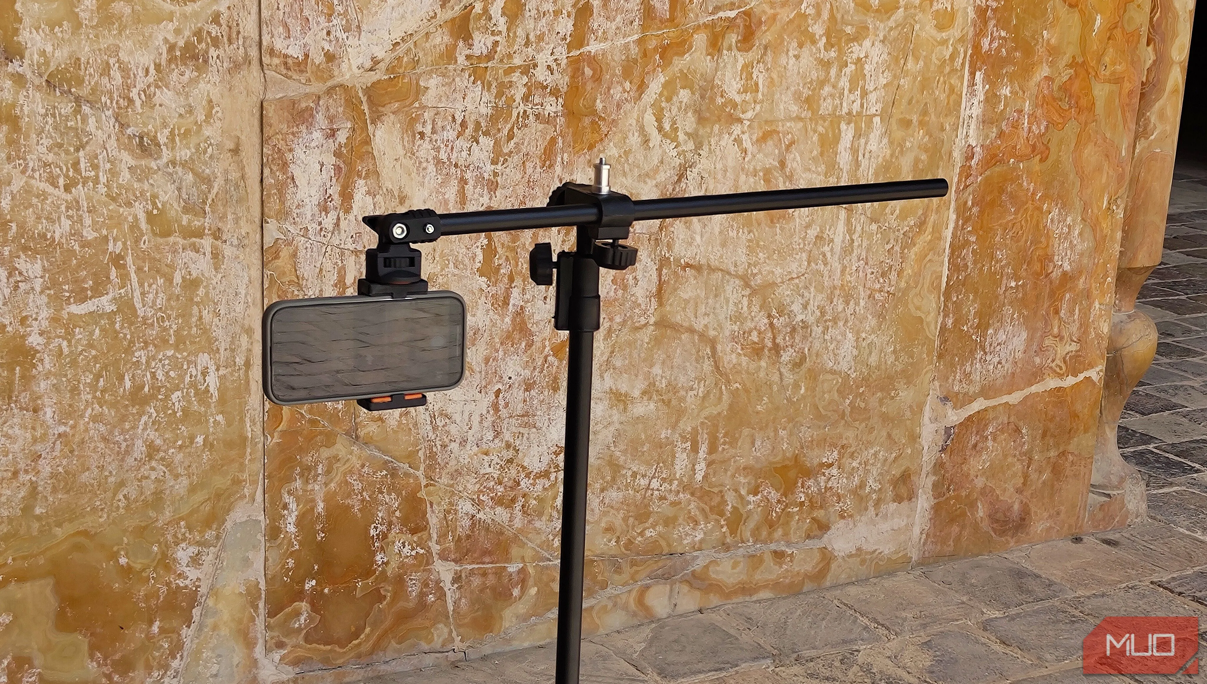 Điện thoại gắn trên tripod hướng về phía bức tường, minh họa việc chọn chủ thể chụp panorama dọc