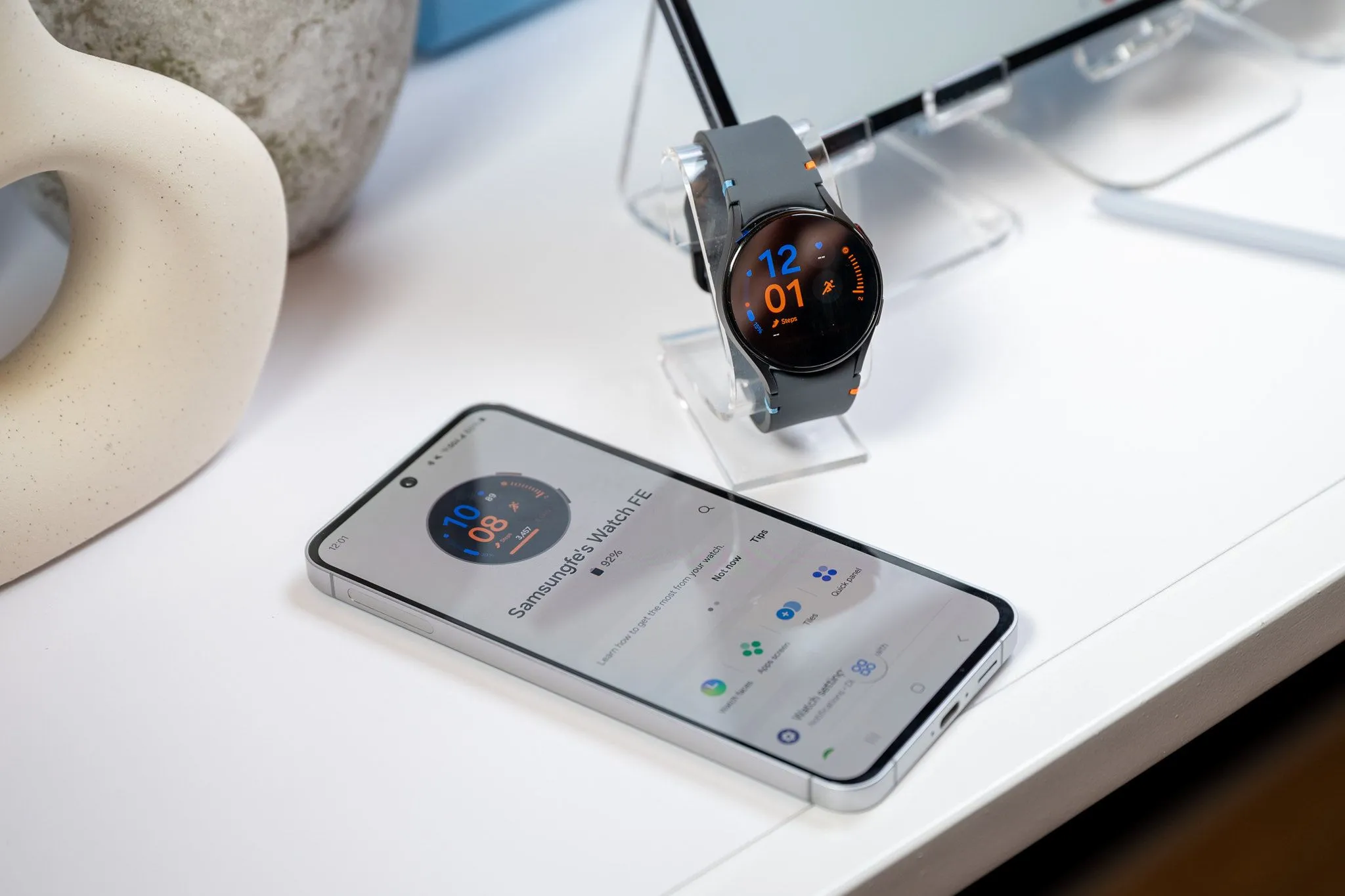 Điện thoại Samsung Galaxy S24 FE đang sạc cho Galaxy Watch LTE qua cáp USB-C