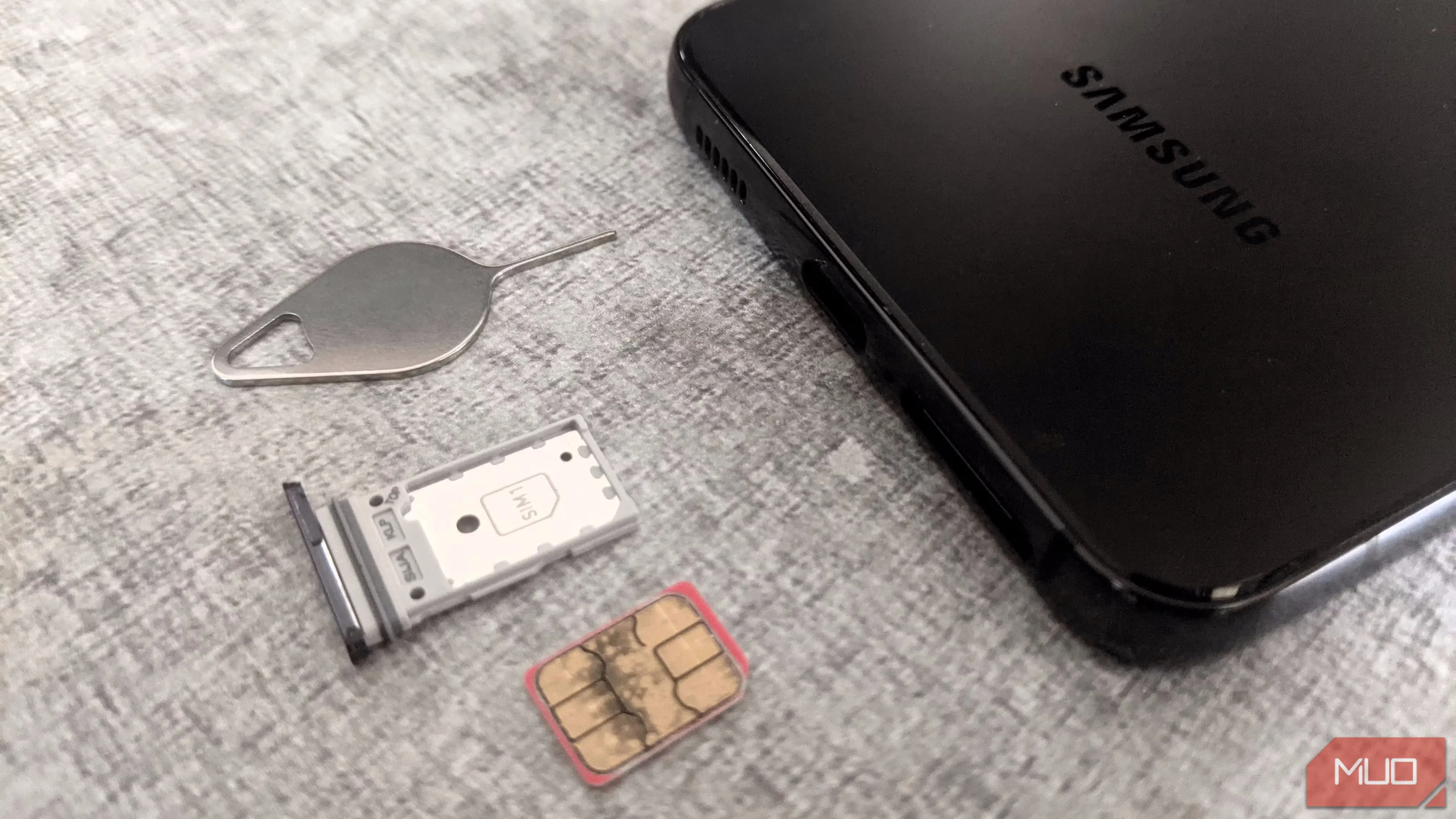 Điện thoại Samsung, khay SIM và cây chọc SIM, minh họa cho mối đe dọa tấn công SIM-swapping.