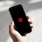 Điện thoại trên tay với ứng dụng Pinterest và Dark Mode
