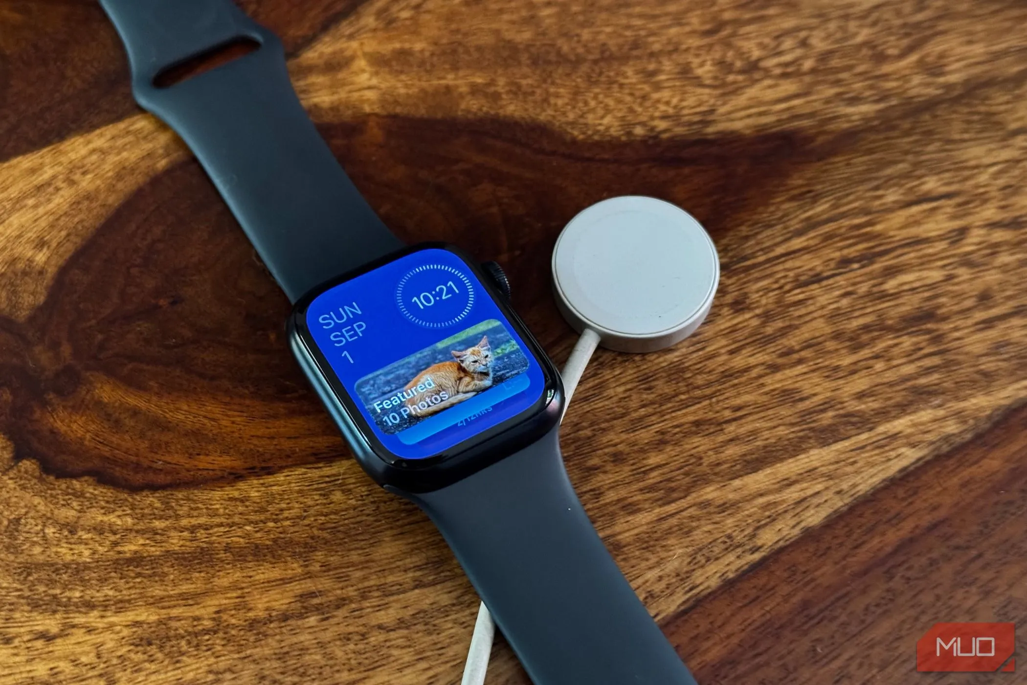 Giao diện Apple Watch với các widget và đế sạc, thể hiện trải nghiệm người dùng liền mạch sau các bản cập nhật phần mềm đồng bộ