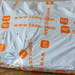 Gói hàng Temu đặt trên bàn, tượng trưng cho việc điều chỉnh giá bán và ảnh hưởng từ chính sách thuế quan mới.