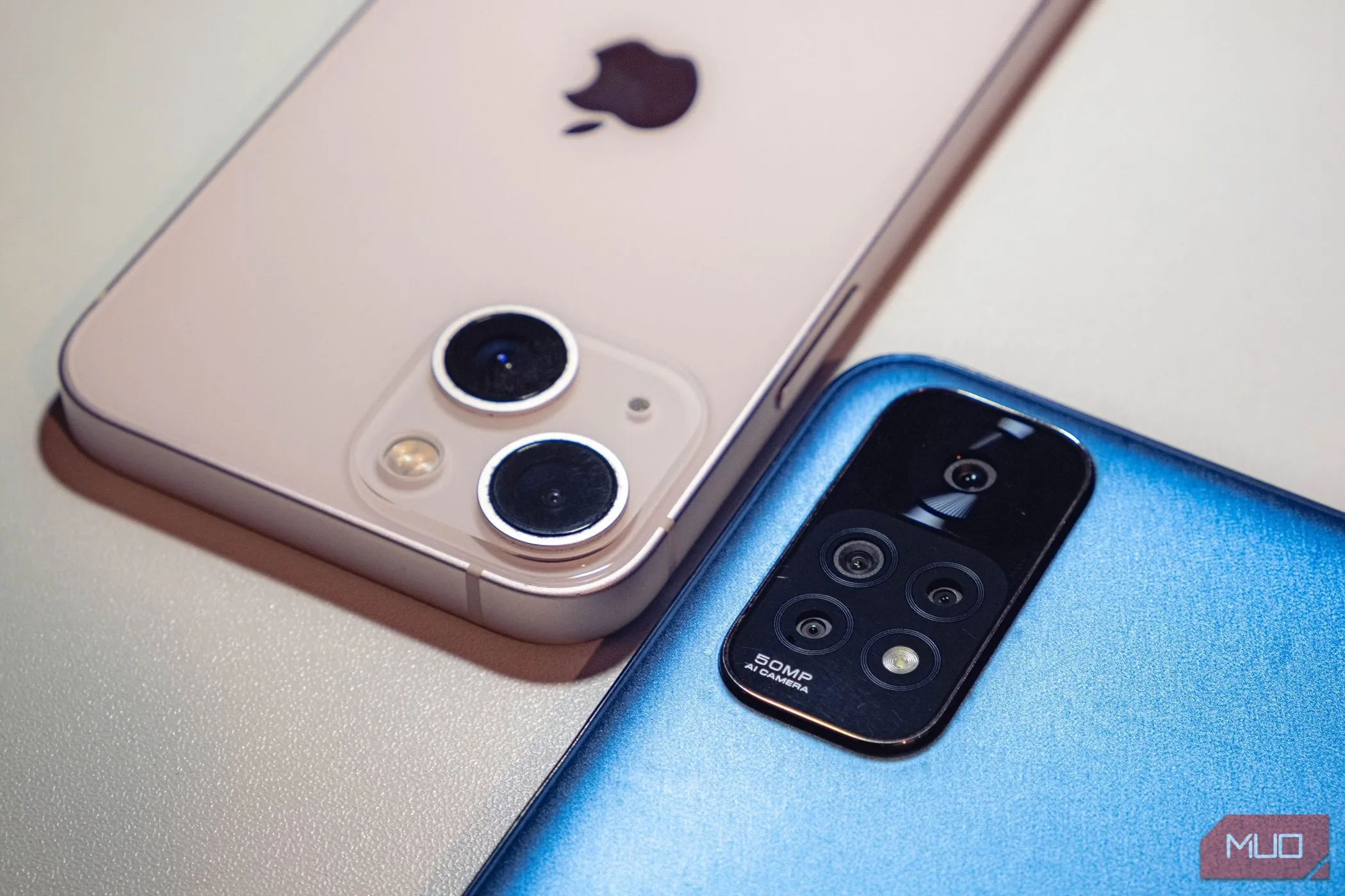 Hai chiếc smartphone màu xanh và hồng đặt úp mặt xuống