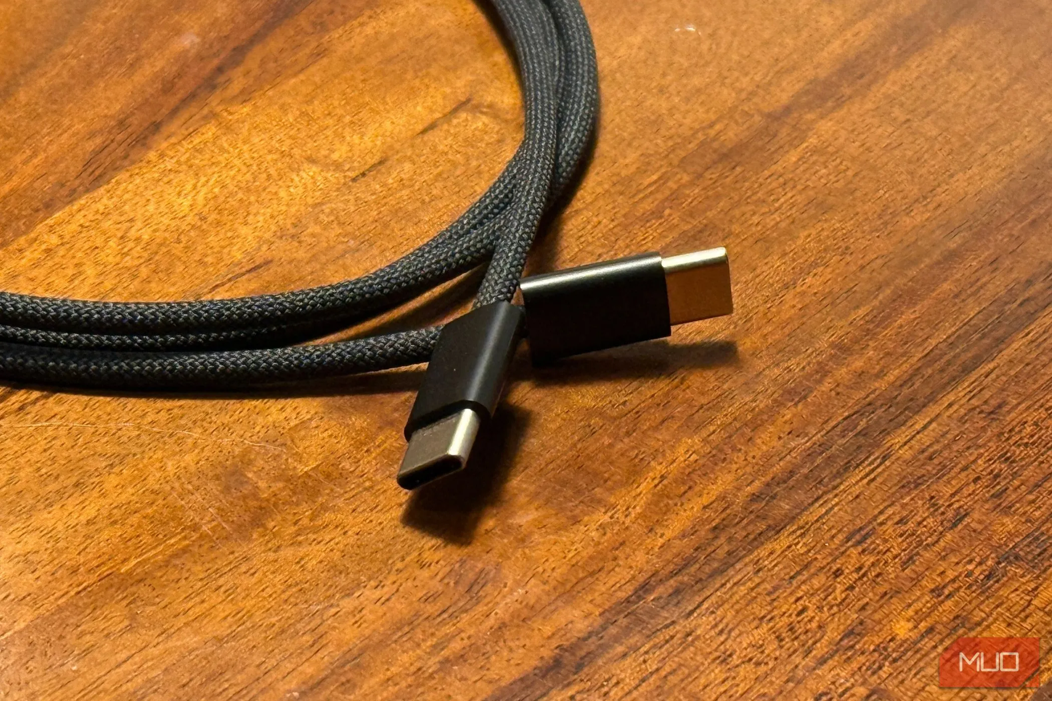 Hai đầu cáp USB-C sang USB-C đặt trên bàn gỗ, loại cáp sạc iPhone phổ biến cho dòng mới
