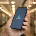 Hình ảnh một người đang cầm điện thoại thông minh, màn hình hiển thị logo WhatsApp, minh họa tính năng phiên âm tin nhắn thoại mới