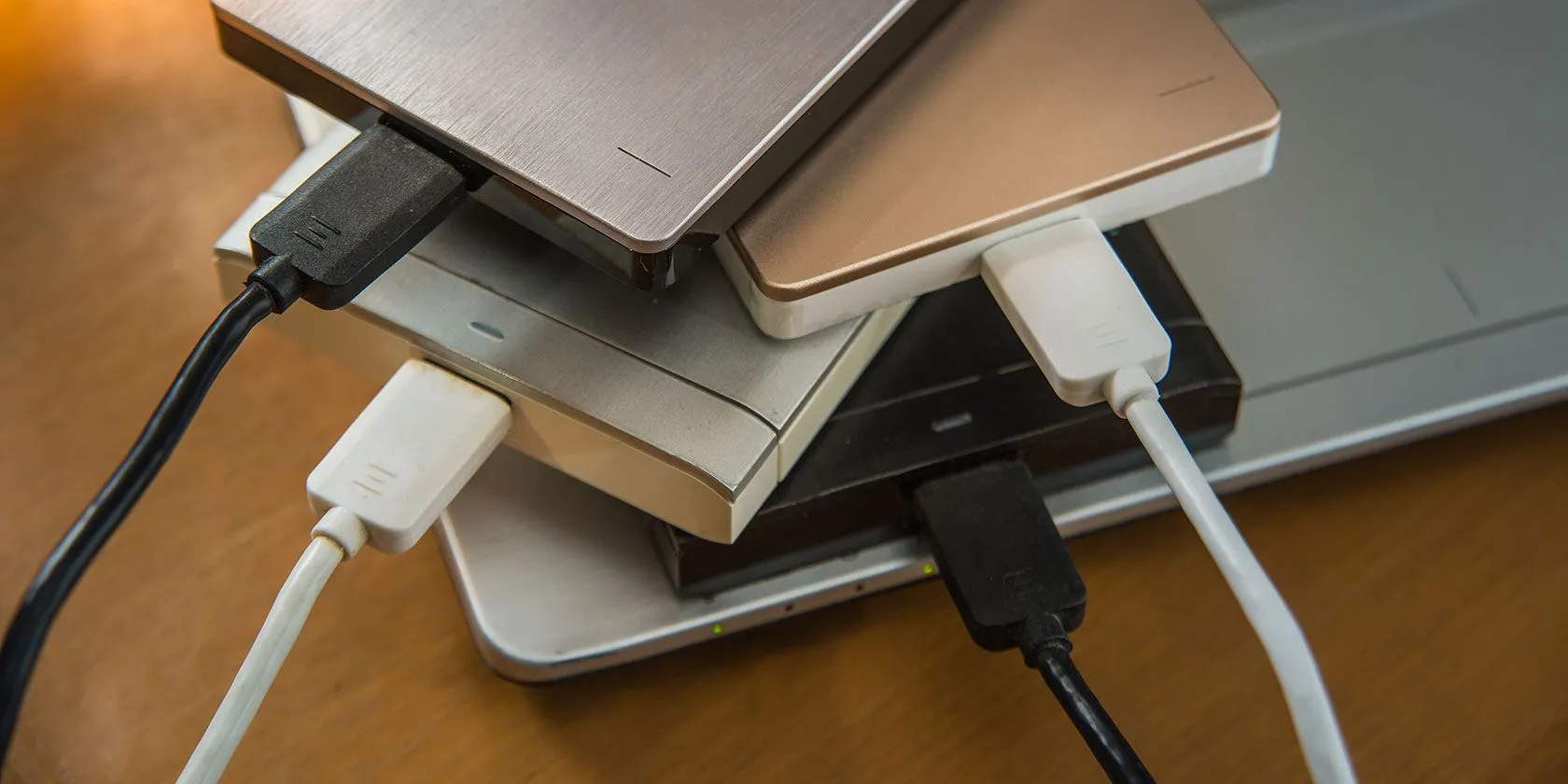 Hình ảnh nhiều ổ cứng rời bên cạnh laptop minh họa sự phức tạp khi quản lý lưu trữ không hiệu quả