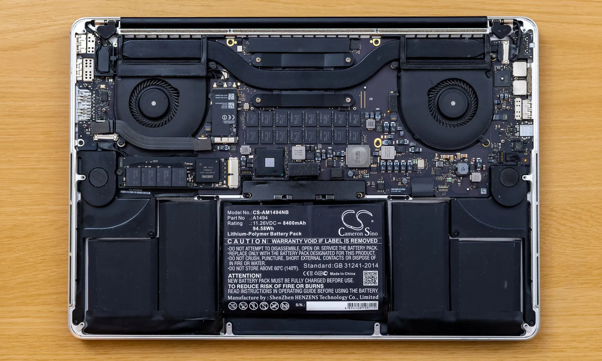 Hình ảnh pin MacBook được tháo rời bên trong, minh họa dung lượng pin hạn chế của laptop mỏng nhẹ.