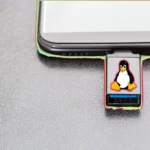 Hình ảnh USB cứu hộ có logo Linux Tux cắm vào laptop, minh họa công cụ khắc phục sự cố máy tính