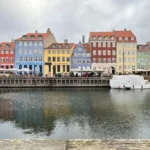 Kênh đào Nyhavn tại Copenhagen với những ngôi nhà nhiều màu sắc và bầu trời u ám, phản chiếu trên mặt nước tĩnh lặng, gợi ý kỹ thuật chụp ảnh phản chiếu trên smartphone