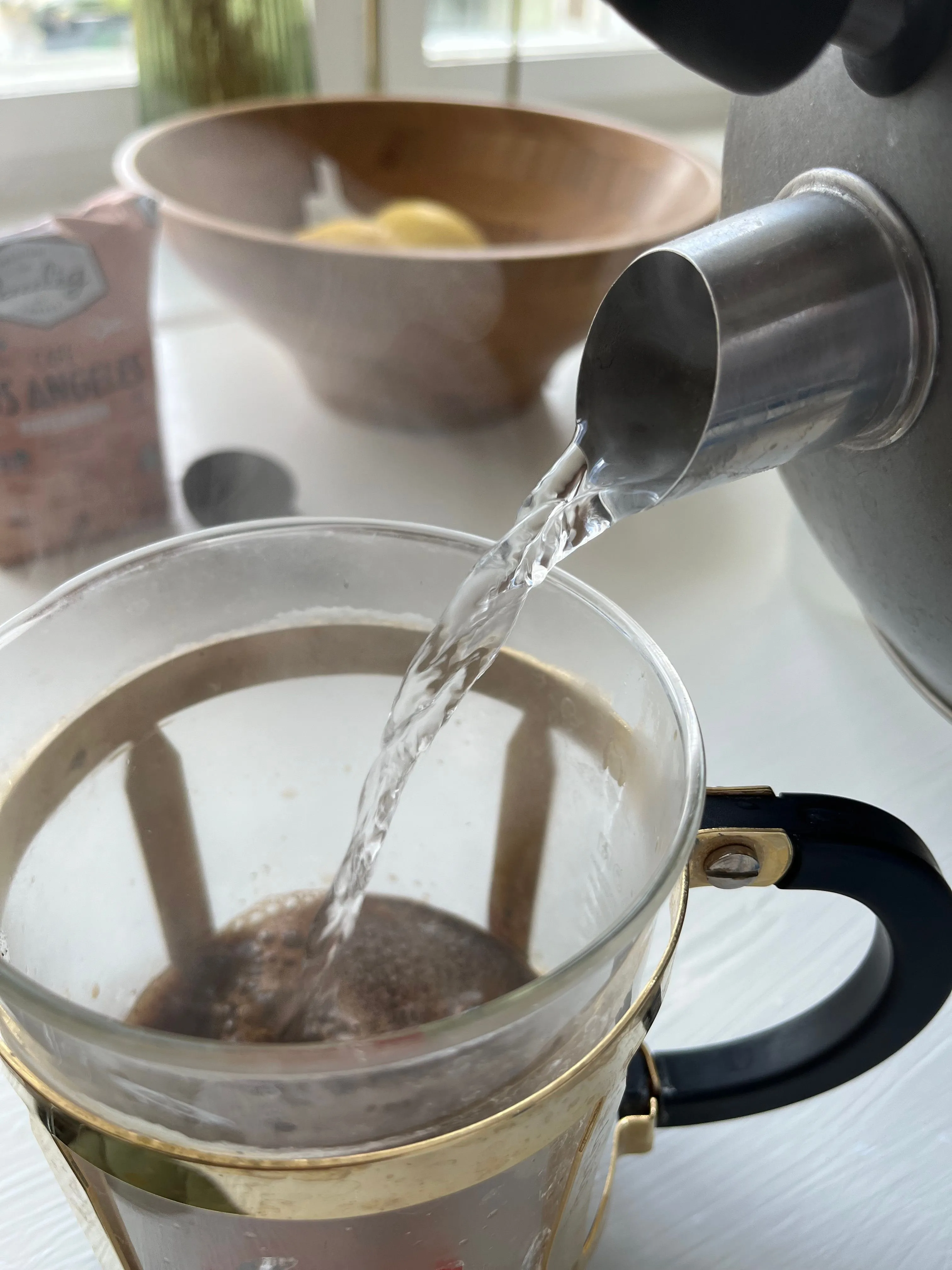 Khoảnh khắc nước nóng từ ấm đang rót vào bình pha cà phê
