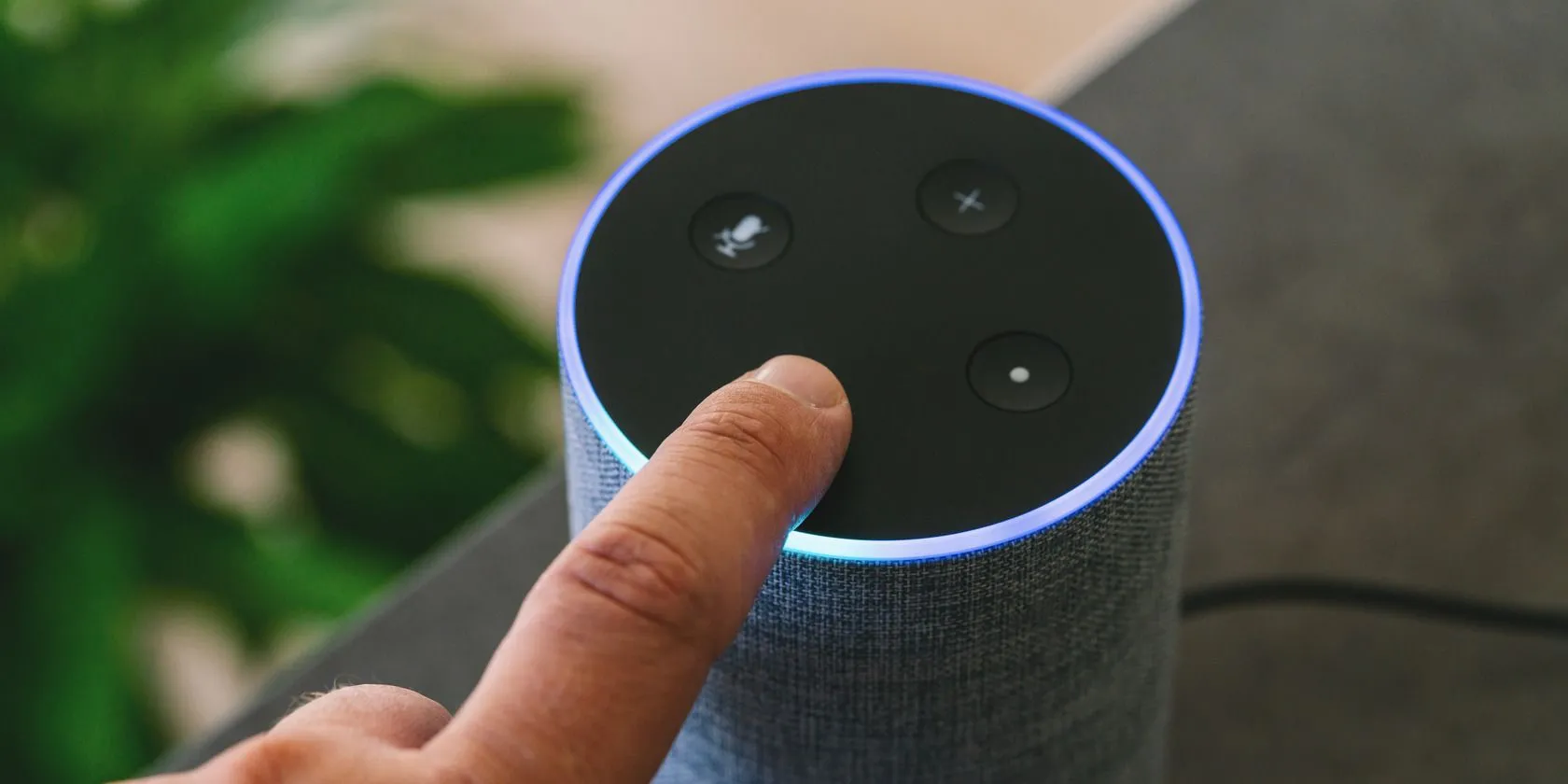 Loa thông minh Amazon Echo trên bàn cạnh một người, tượng trưng cho trợ lý giọng nói luôn sẵn sàng lắng nghe