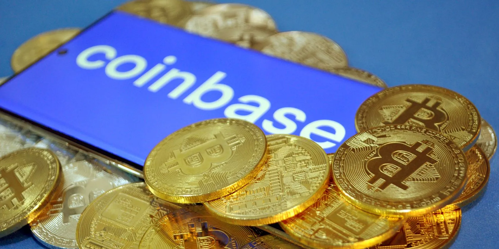 Logo sàn giao dịch tiền điện tử Coinbase và các đồng Bitcoin, minh họa sự cố rò rỉ dữ liệu