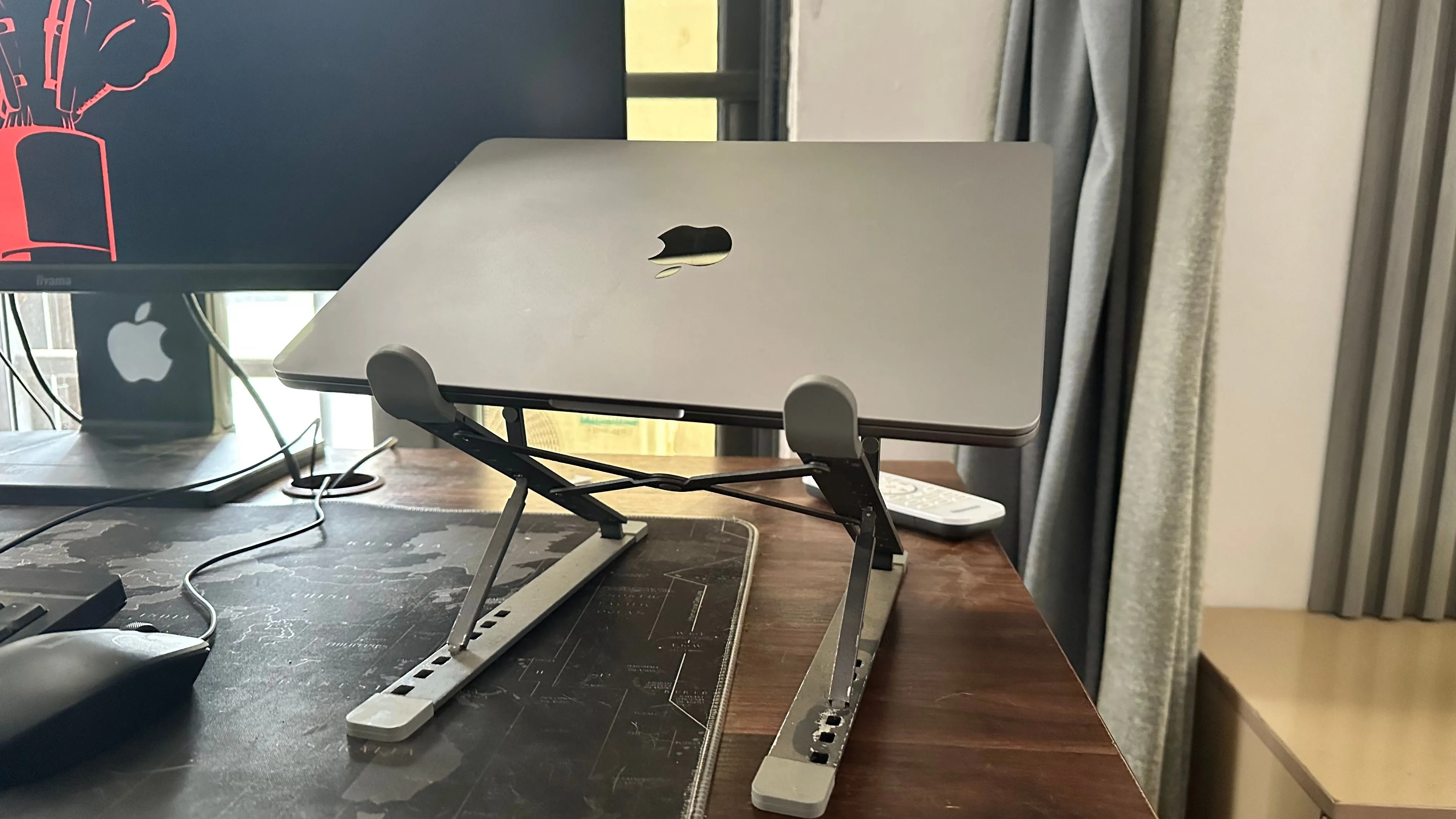 MacBook đặt trên giá đỡ tản nhiệt bên cạnh màn hình phụ