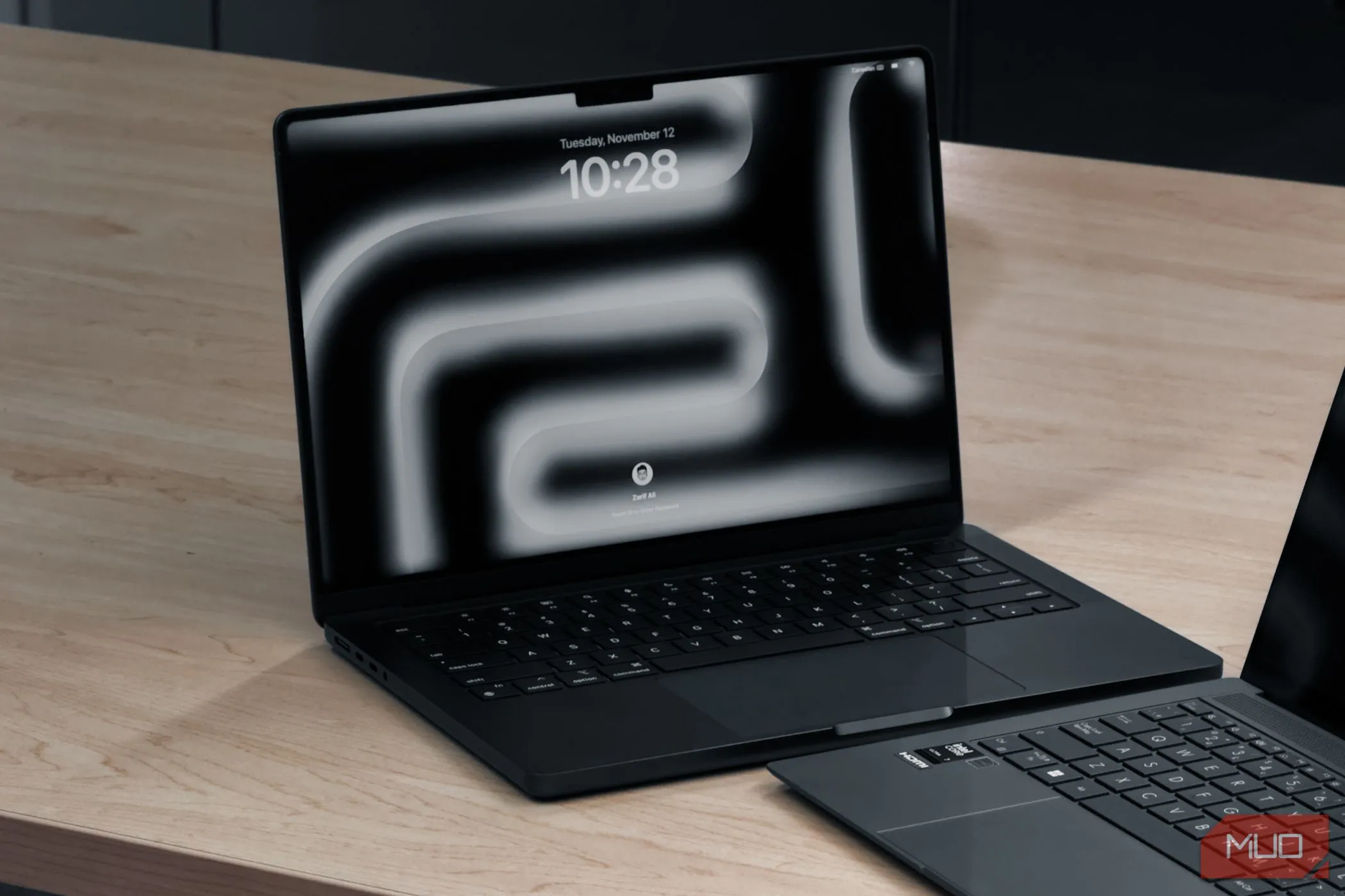 MacBook Pro M4 và một laptop khác đặt trên bàn gỗ, thể hiện thiết kế cao cấp và hiệu năng của dòng máy macOS.