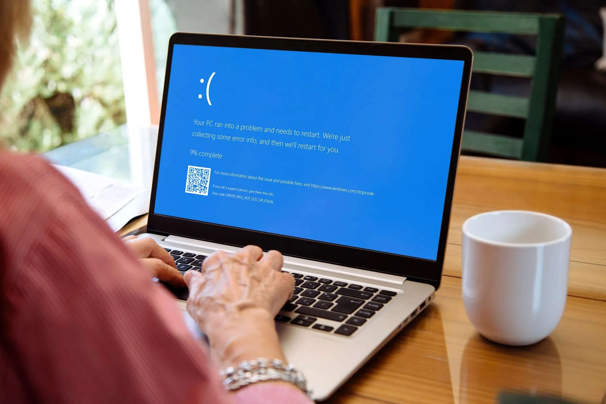 Màn hình xanh chết chóc (BSOD) xuất hiện trên laptop Windows khi một người phụ nữ đang sử dụng