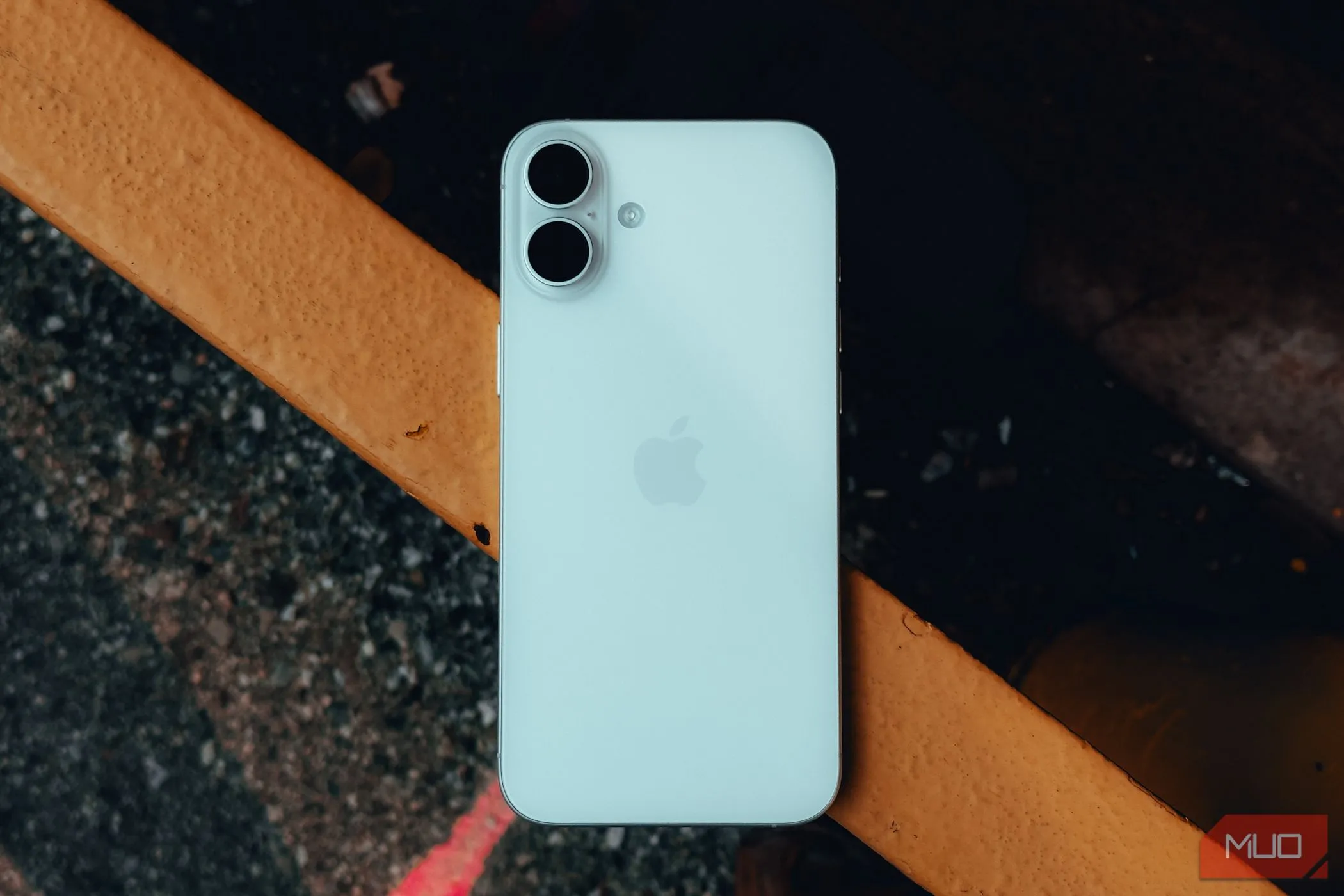Mặt lưng iPhone 16 Plus đặt trên lan can, minh họa tính năng Chạm mặt lưng (Back Tap)