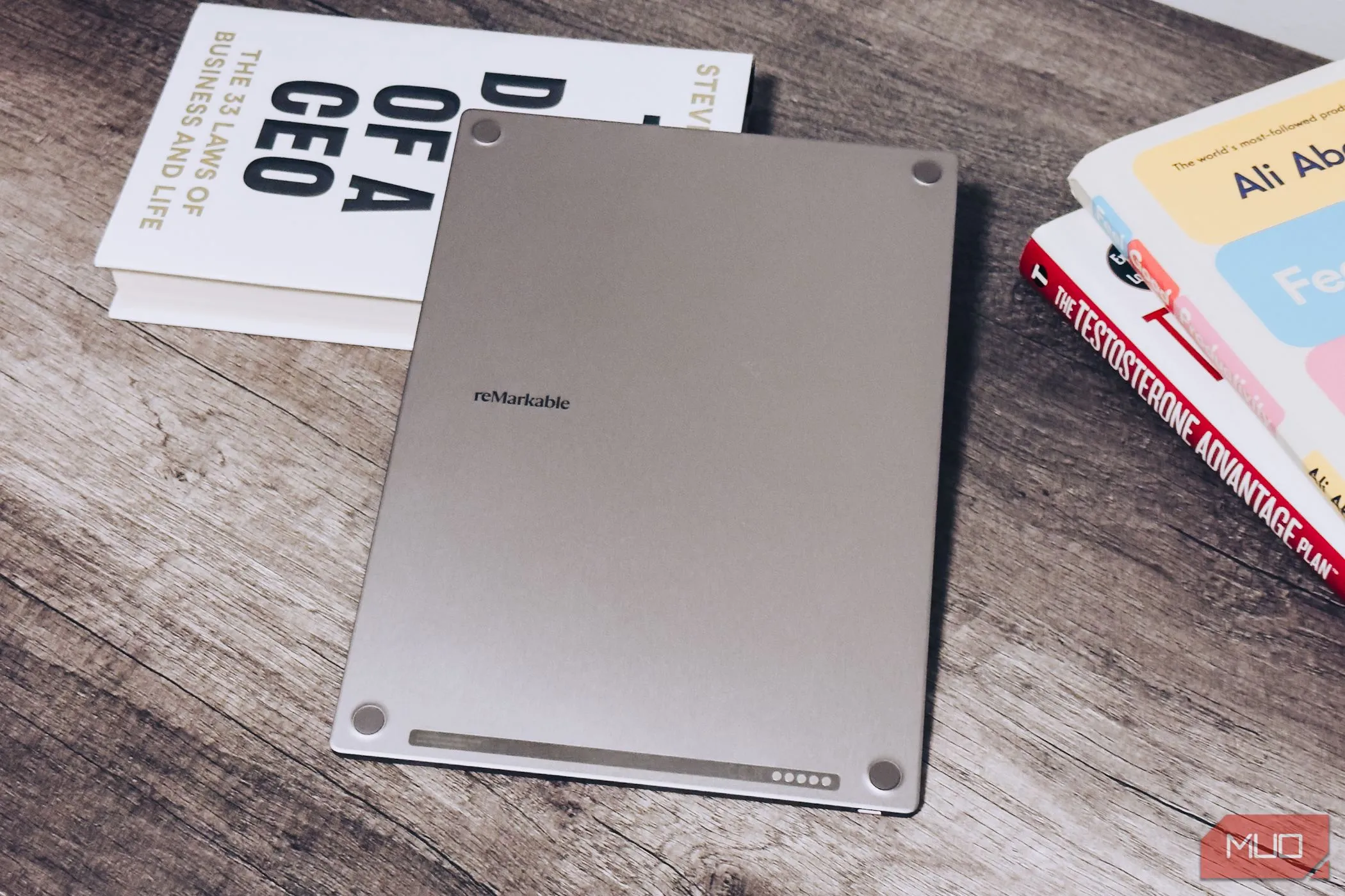 Mặt sau của reMarkable Paper Pro đặt trên bàn gỗ, bên cạnh những cuốn sách