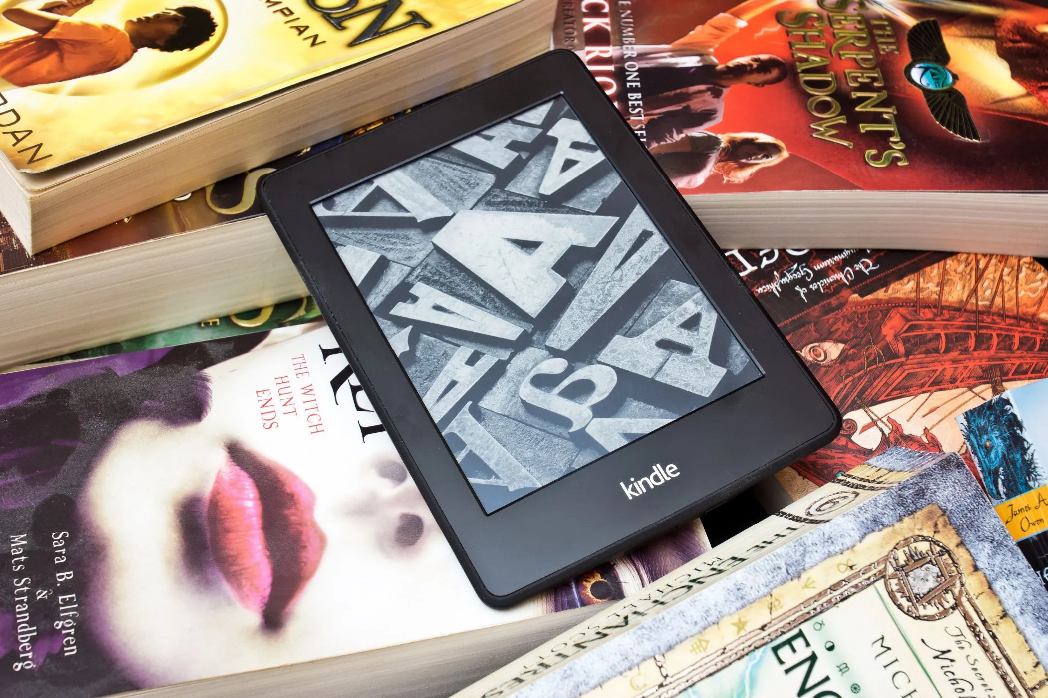 Máy đọc sách Kindle trên chồng sách vật lý, biểu tượng cho thư viện số và sách in