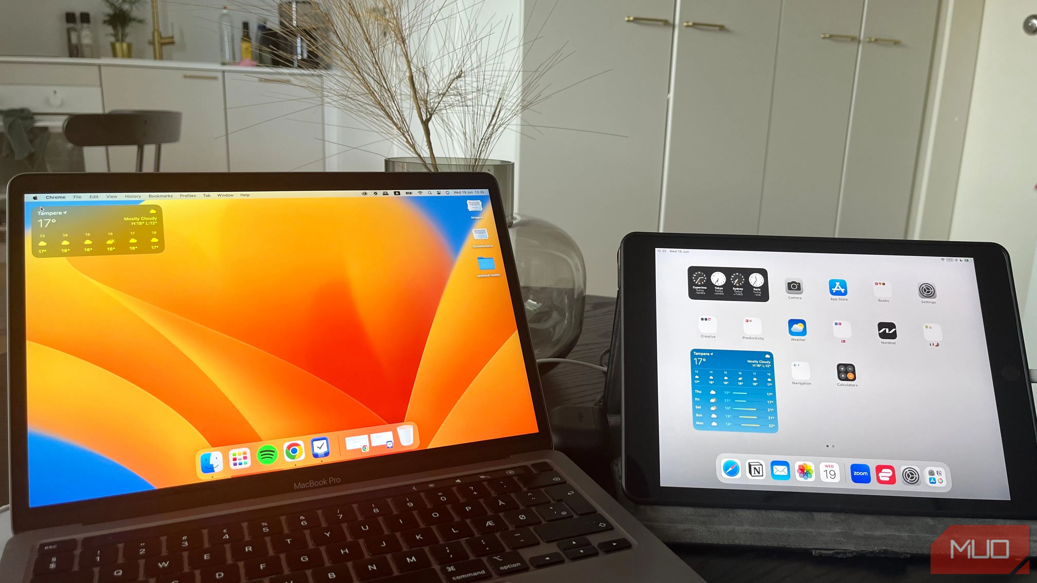 Máy tính MacBook và iPad đặt cạnh nhau trên bàn làm việc, minh họa cách sử dụng iPad làm màn hình phụ