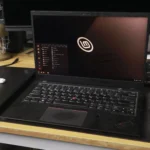 Máy tính xách tay ThinkPad với giao diện Linux Mint, bên cạnh là chuột và USB.