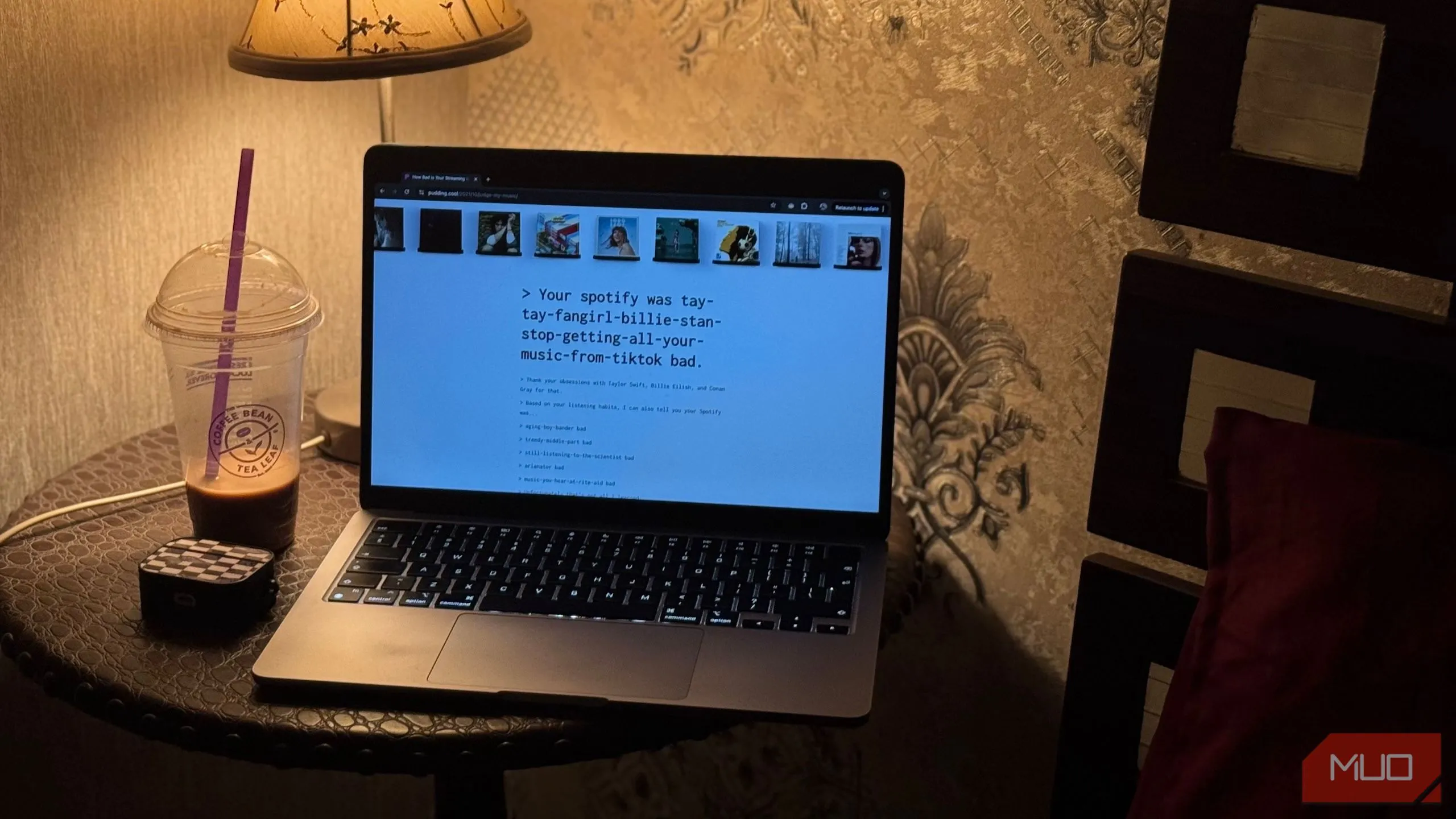 Một chiếc MacBook hiển thị trang web &quot;How Bad is Your Streaming Music&quot; cùng với cốc cà phê, minh họa trải nghiệm duyệt web hàng ngày trên máy tính xách tay.