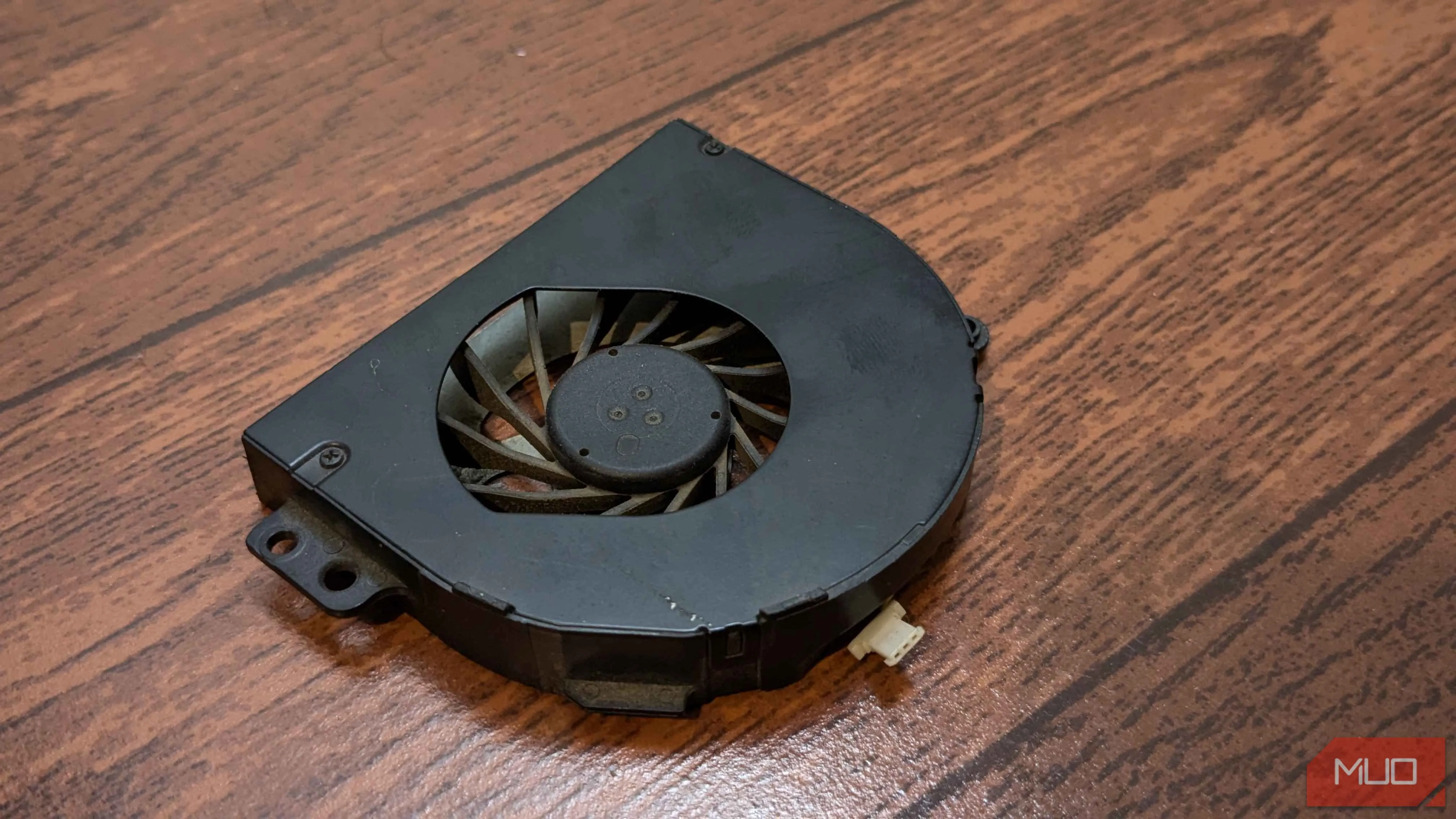 Một chiếc quạt tản nhiệt laptop riêng lẻ nằm trên bề mặt phẳng, sẵn sàng để thay thế