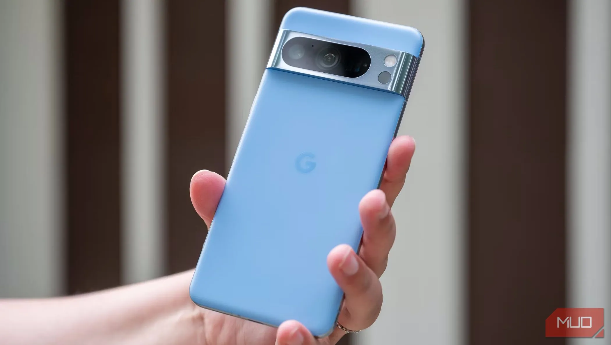 Một người đàn ông đang cầm điện thoại Pixel 8 Pro quay lưng ra ngoài