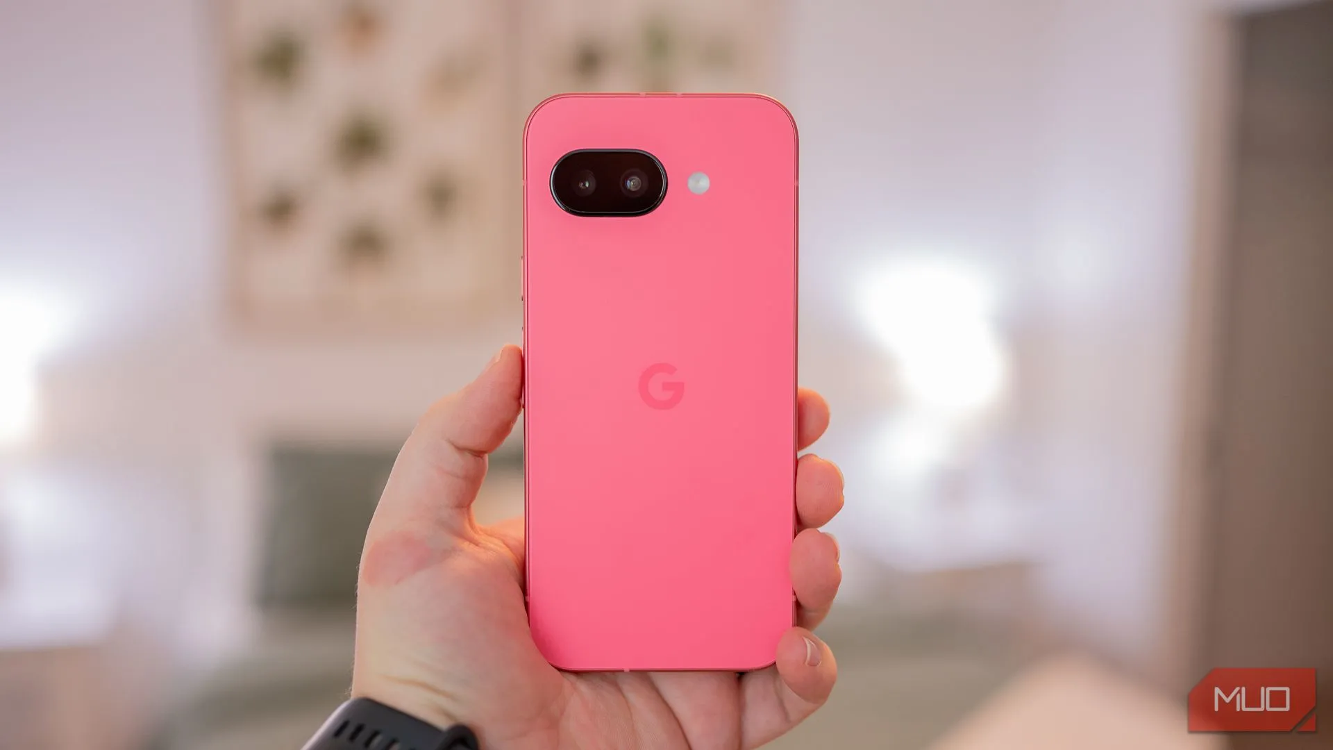 Một người đang cầm Google Pixel 9a, mặt lưng màu xanh tím 'Iris' với thiết kế tối giản và khung kim loại
