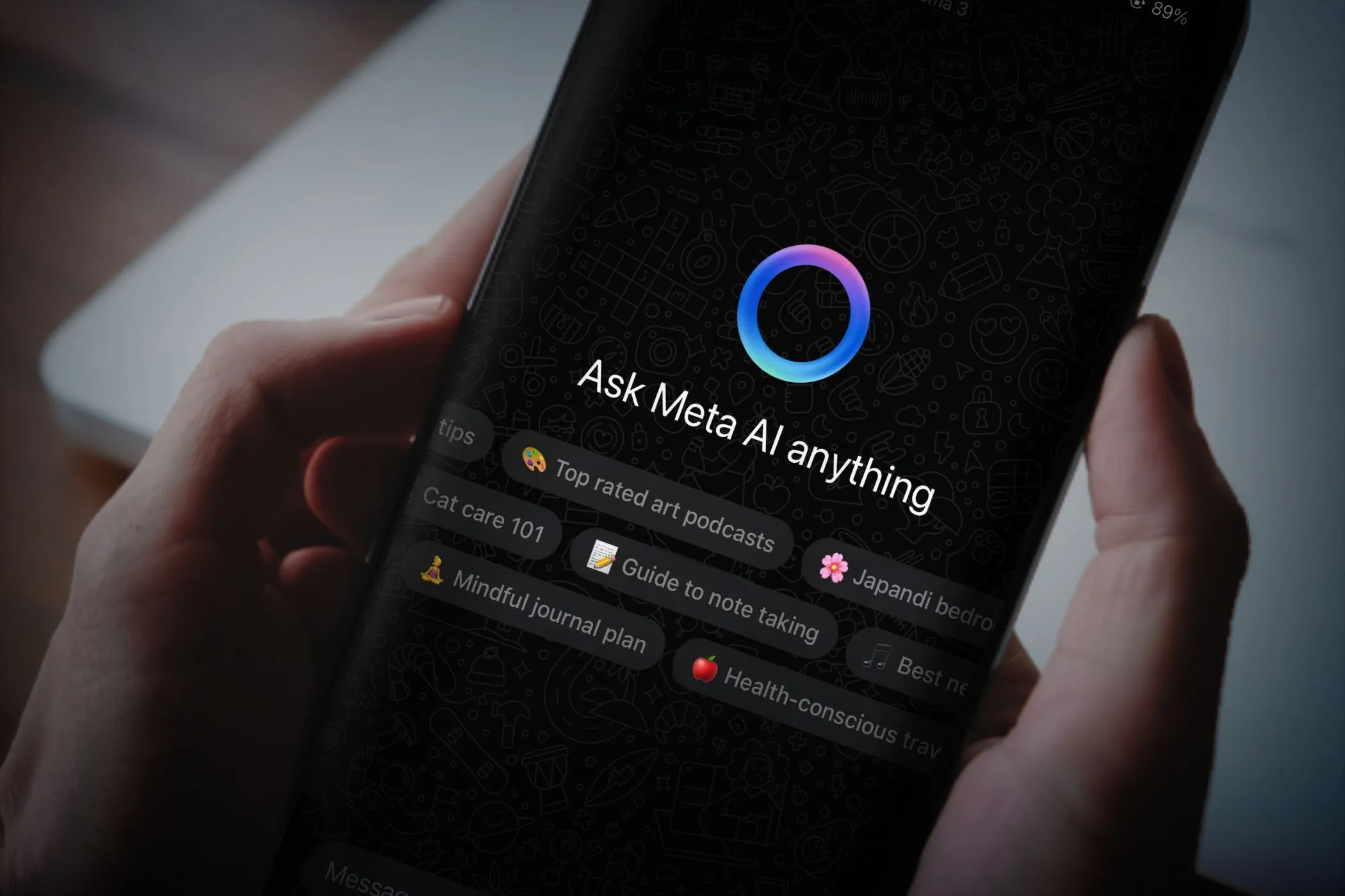 Một người dùng đang cầm điện thoại thông minh với ứng dụng WhatsApp mở, hiển thị giao diện trò chuyện cùng chatbot Meta AI trên màn hình.