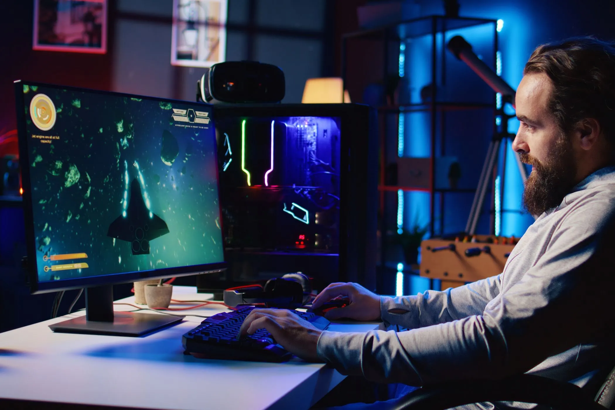 Người đàn ông đang chơi game trên máy tính để bàn, trải nghiệm kết nối ổn định với cáp mạng Ethernet.