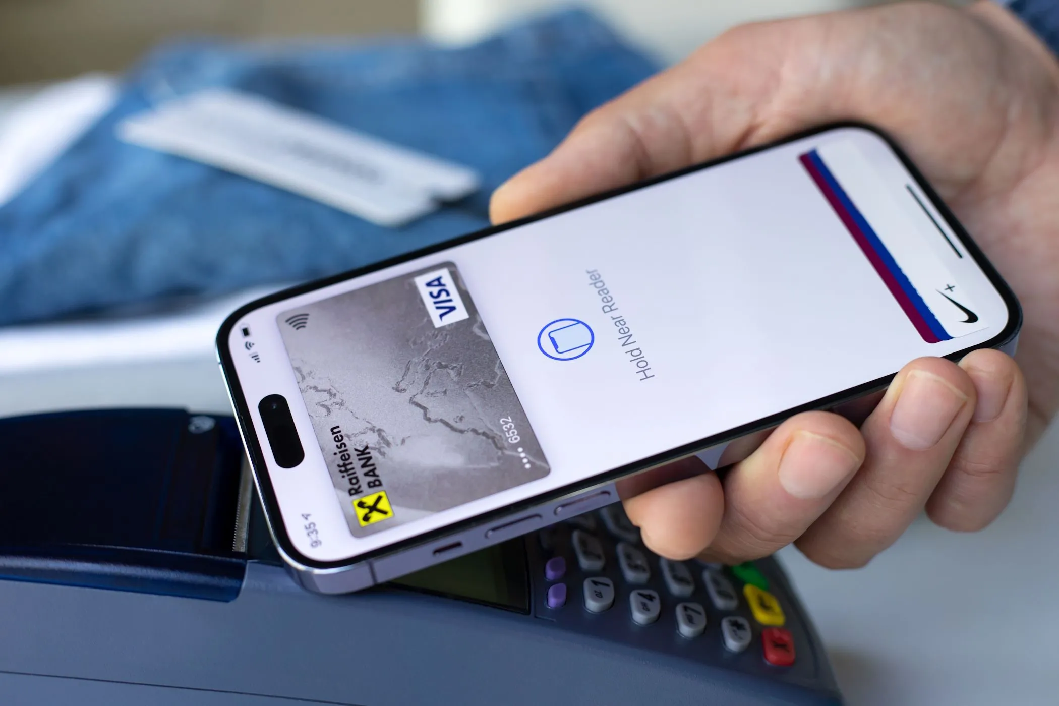 Người đàn ông sử dụng Apple Pay trên iPhone để thanh toán tại cửa hàng