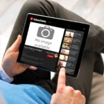 Người đàn ông thất vọng khi xem video trực tuyến bị gián đoạn trên máy tính bảng do mất kết nối internet, minh họa hạn chế của Chromebook khi ngoại tuyến.