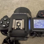 Người dùng đang điều chỉnh cài đặt trên màn hình máy ảnh Mirrorless, thể hiện sự phức tạp và ảnh hưởng đến pin