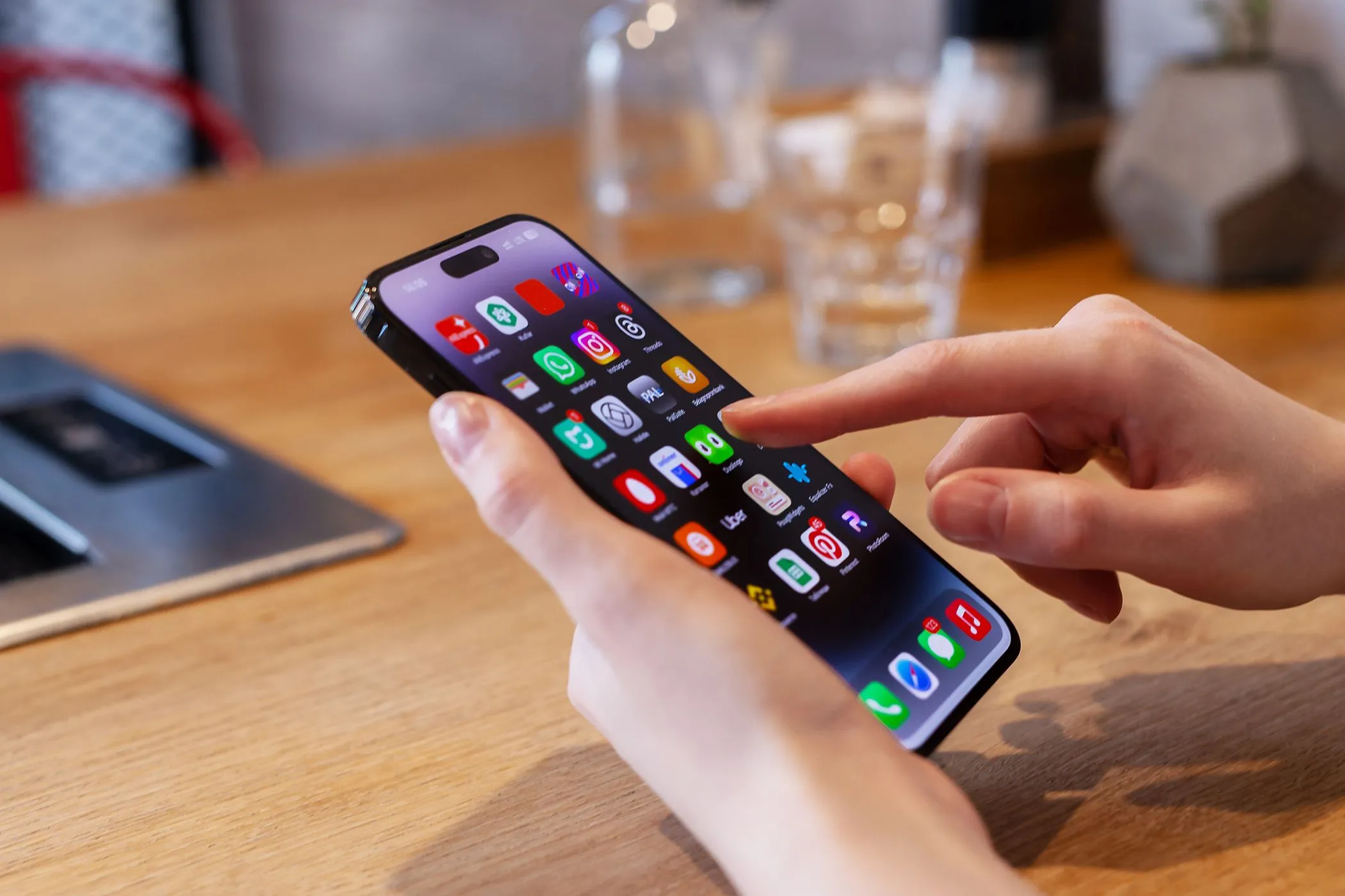 Người dùng đang sử dụng iPhone tại bàn, gợi ý nhu cầu về tính năng mới