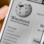 Người dùng điện thoại mở ứng dụng Wikipedia để tra cứu thông tin, minh họa cách AI hỗ trợ việc tìm kiếm kiến thức.