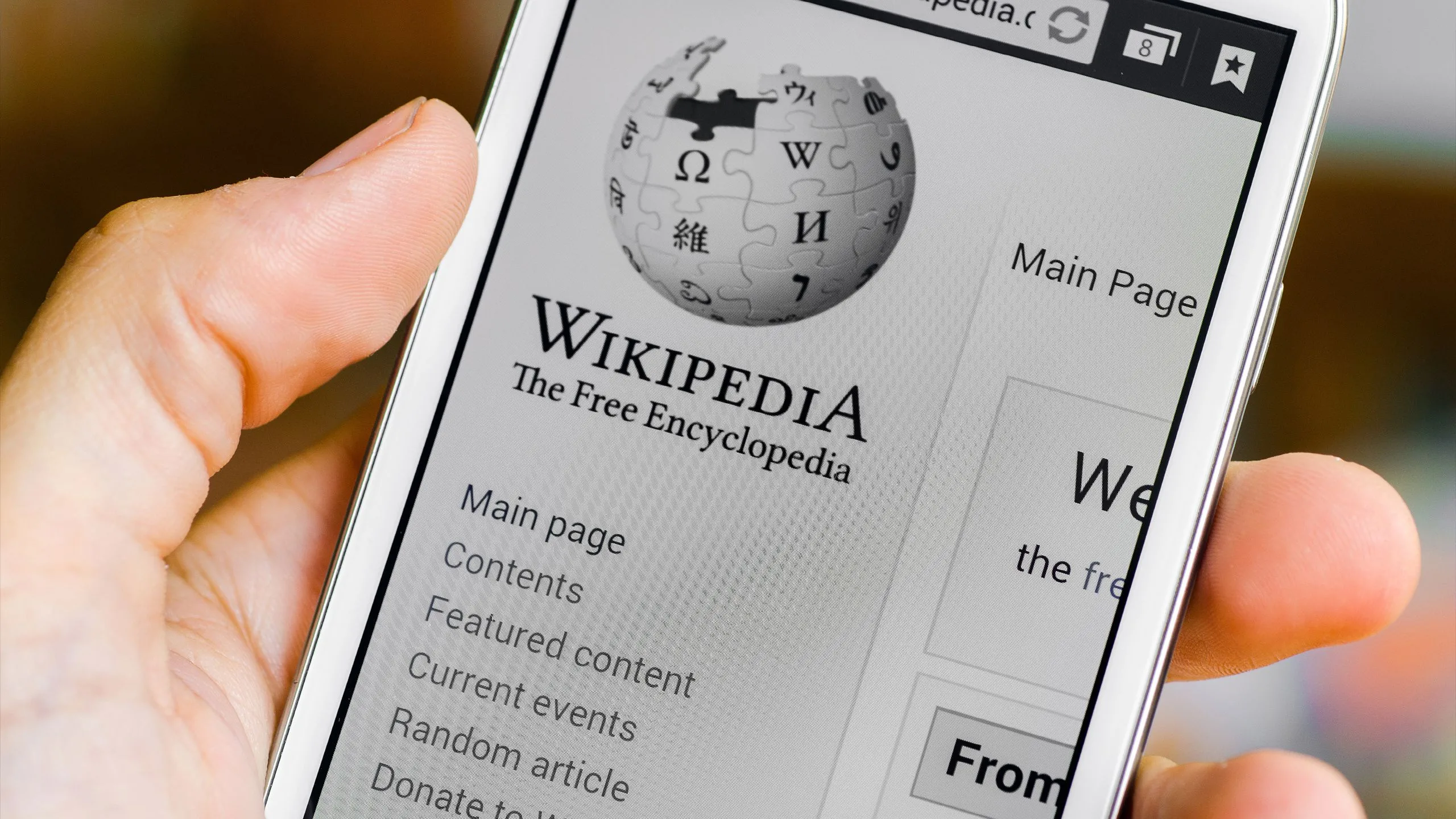 Người dùng điện thoại mở ứng dụng Wikipedia để tra cứu thông tin, minh họa cách AI hỗ trợ việc tìm kiếm kiến thức.