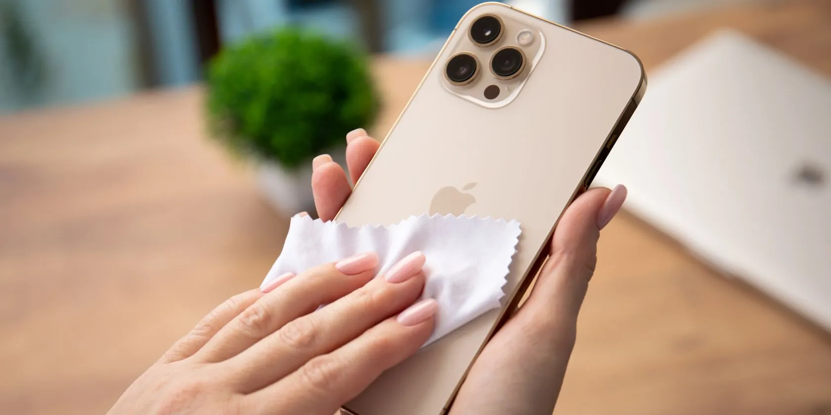 Người phụ nữ đang vệ sinh màn hình iPhone bằng khăn vi sợi chuyên dụng