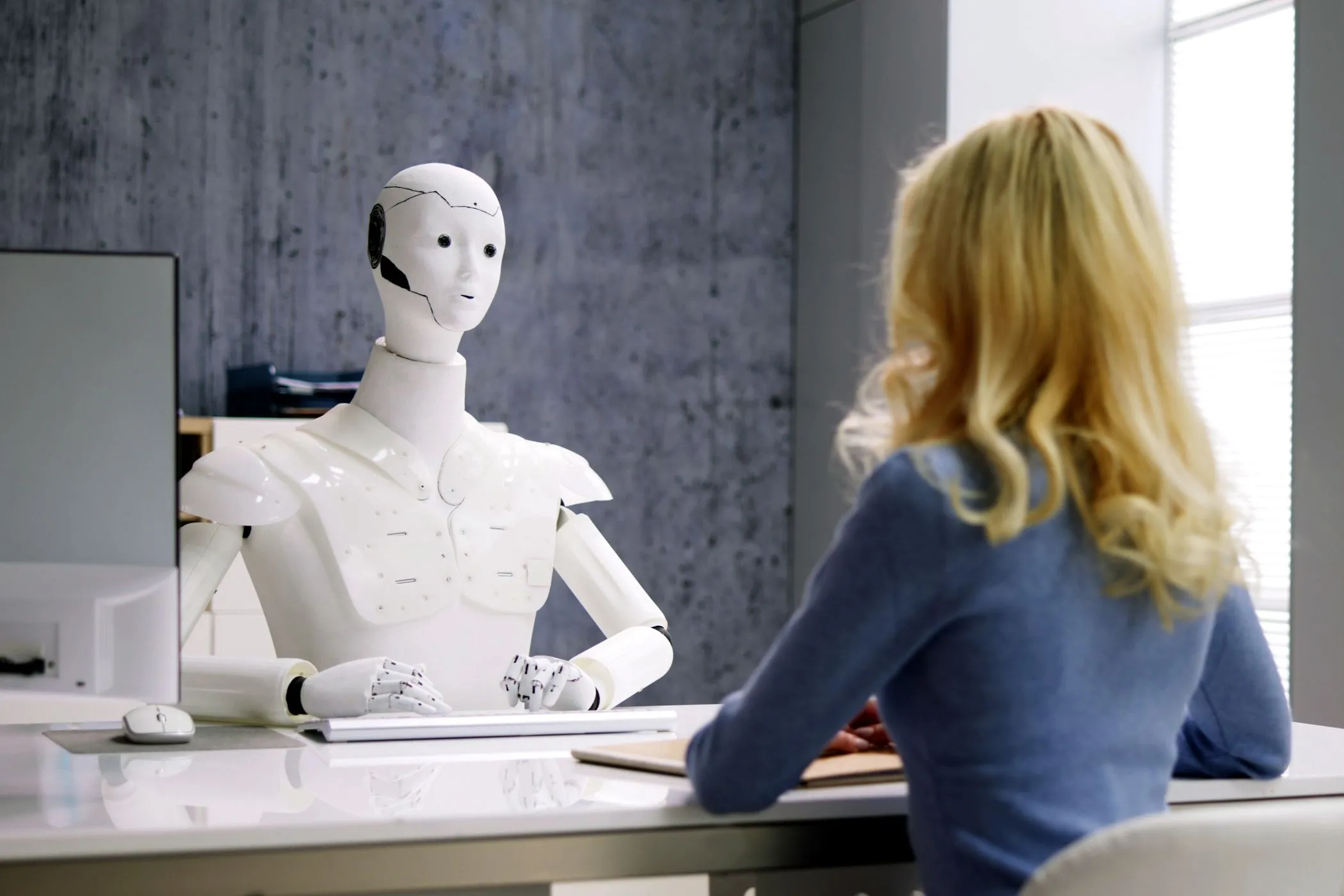 Người phụ nữ phỏng vấn với robot AI, minh họa khả năng tương tác và tự chủ của tác nhân AI trong môi trường làm việc