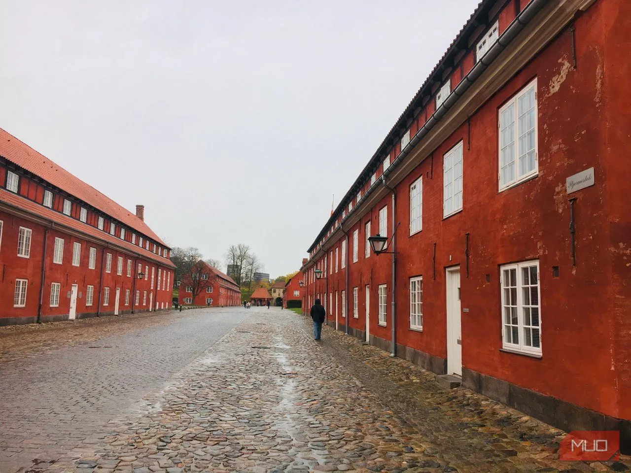 Những doanh trại màu đỏ tại pháo đài Kastellet nổi bật dưới bầu trời mây, cho thấy các đường nét và bố cục hình học trong nhiếp ảnh cảnh quan đô thị