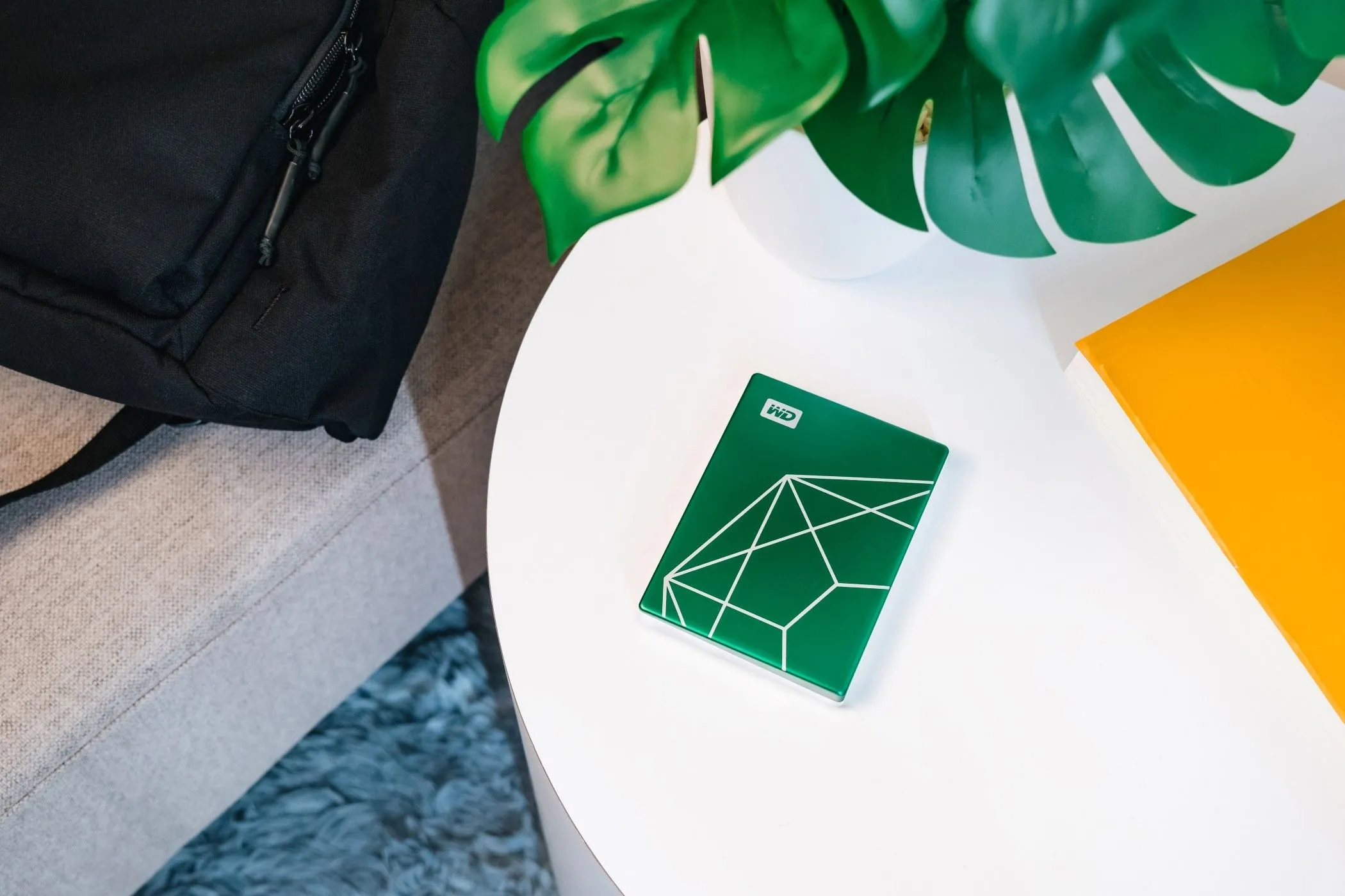 Ổ cứng WD My Passport Ultra 20th Anniversary Edition đặt trên bàn làm việc, nhỏ gọn và tiện lợi