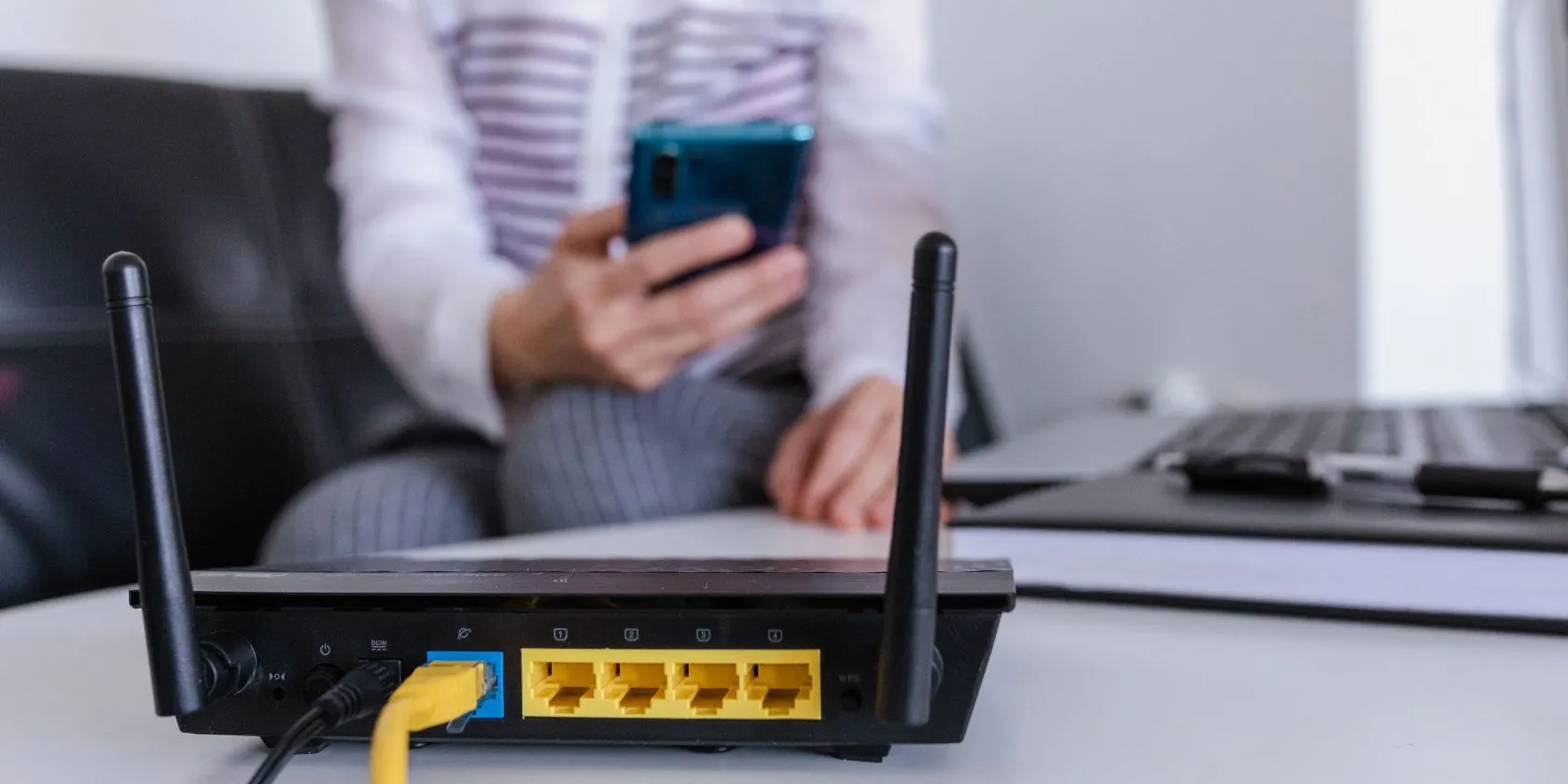 Router Wi-Fi đang hoạt động với hình ảnh người dùng ở hậu cảnh, minh họa rủi ro bảo mật UPnP.